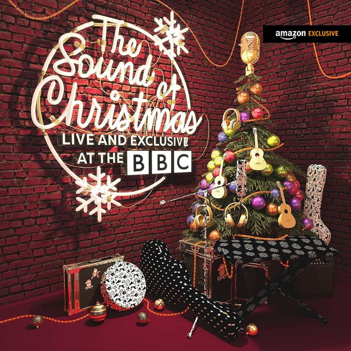 Weihnachtsszene: Weihnachtsbaum mit Ornamenten und Gitarren. Schild: The Sound of Christmas. Amazon Exklusiv und BBC Logo.