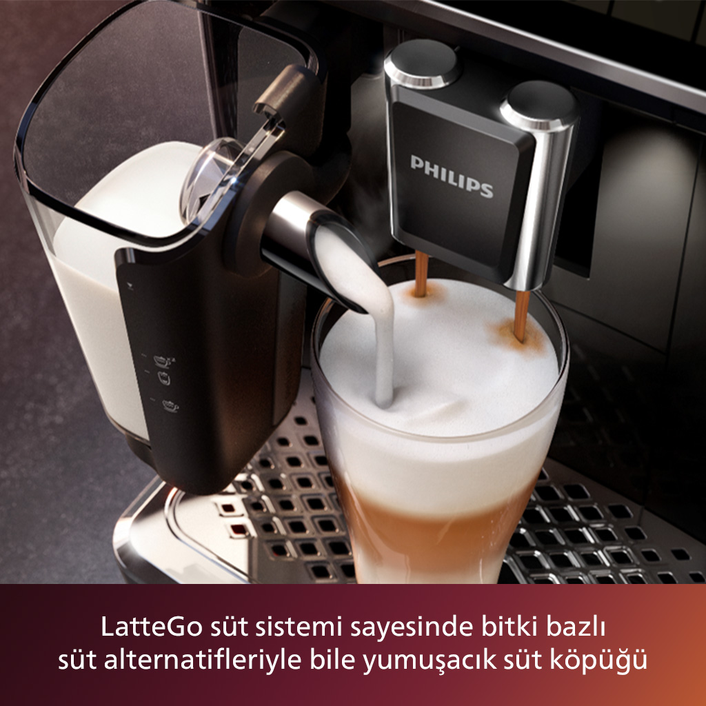 Bir kahve makinesi, bir kahve bardağına süt köpüğü döküyor. Makinede bir süt kabı ve bir Philips logosu var.