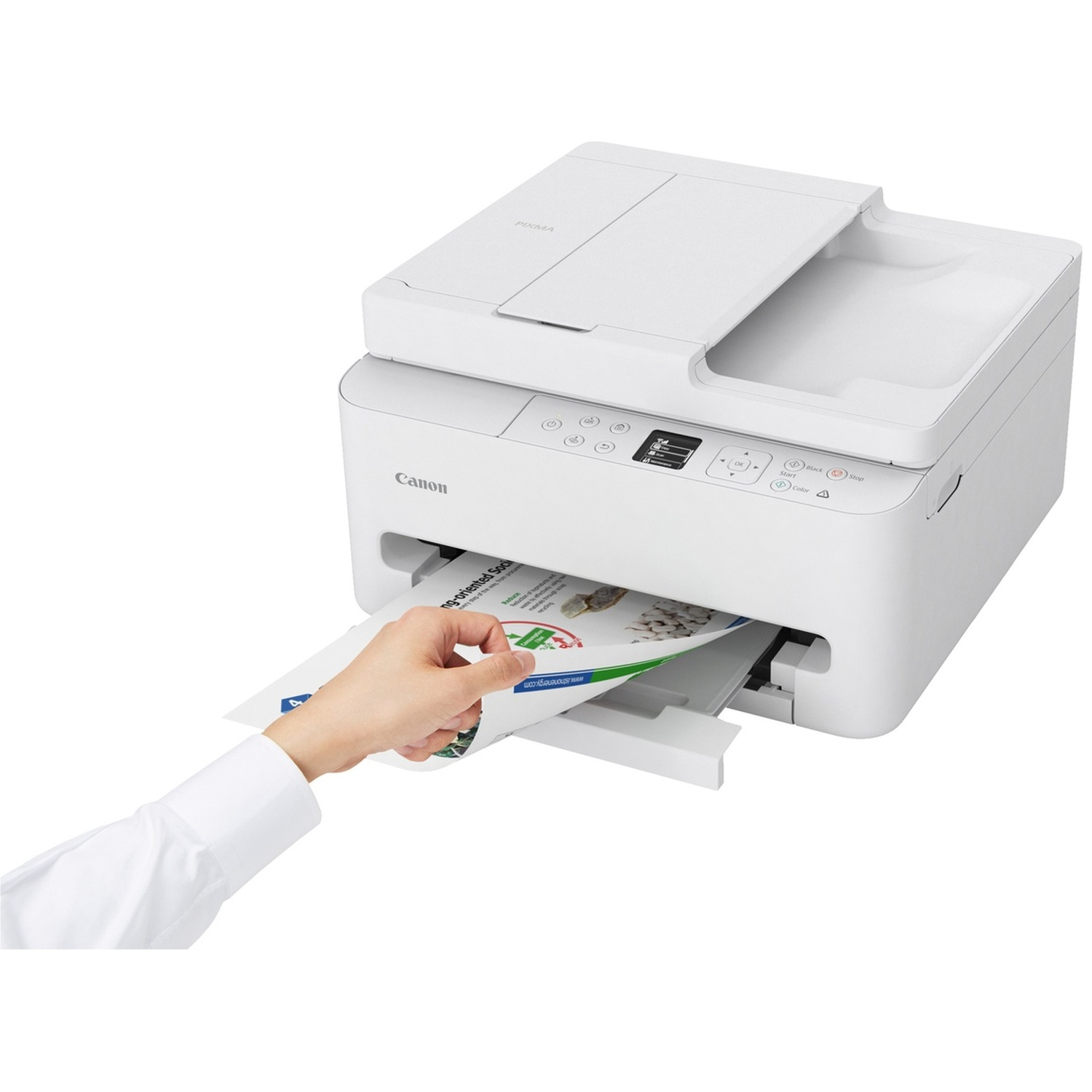 A white Canon printer. A hand in a white shirt pulls a printed paper from the printer. The printer is on a white background.