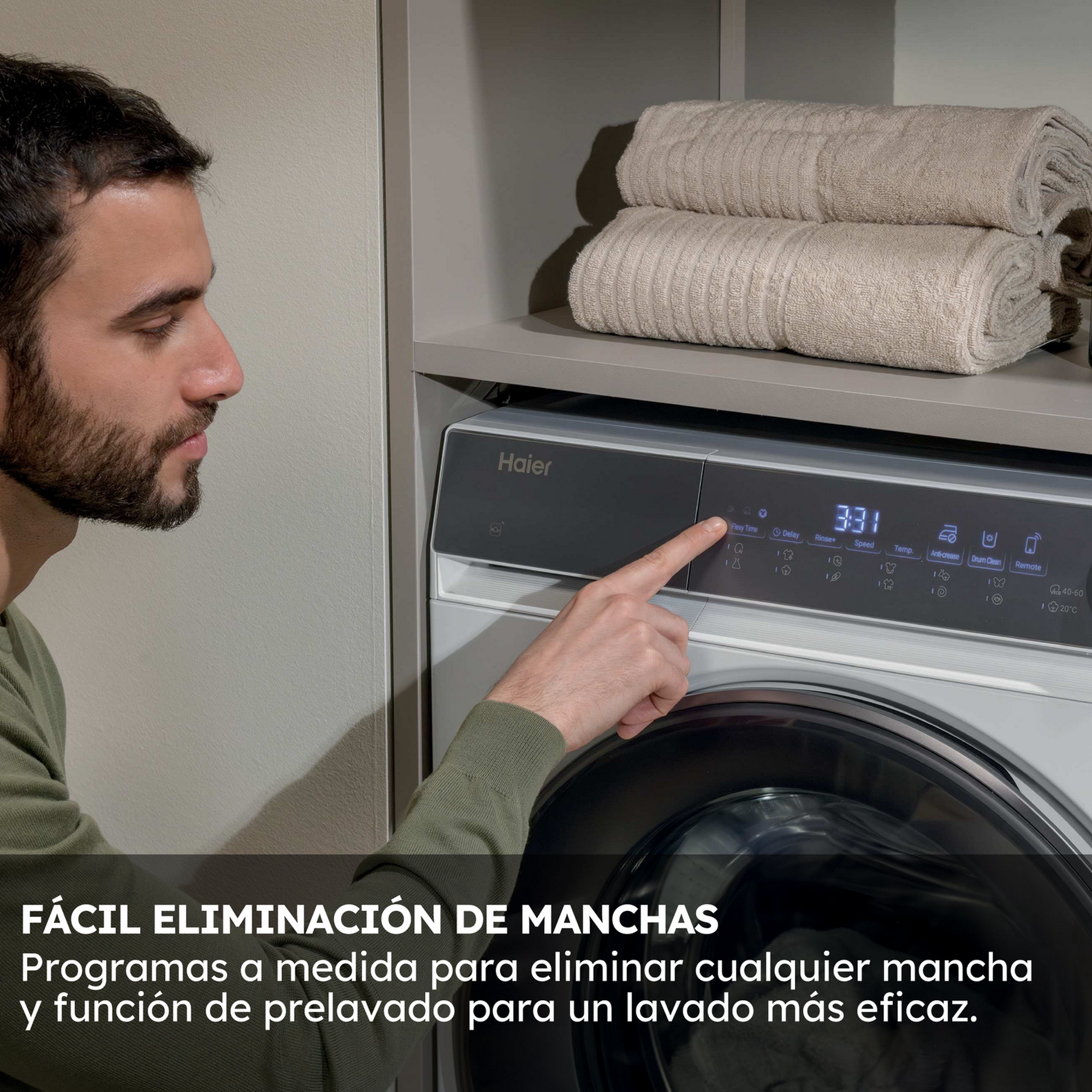 Un hombre señala el panel de control de una lavadora. Dos toallas están sobre un estante. Texto: Fácil eliminación de manchas.
