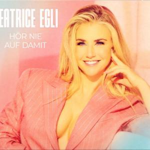 Blonde Frau in rosa Blazer lächelt. Text: Beatrice Egli, Hör nie auf damit. Hintergrund rosa und blau.