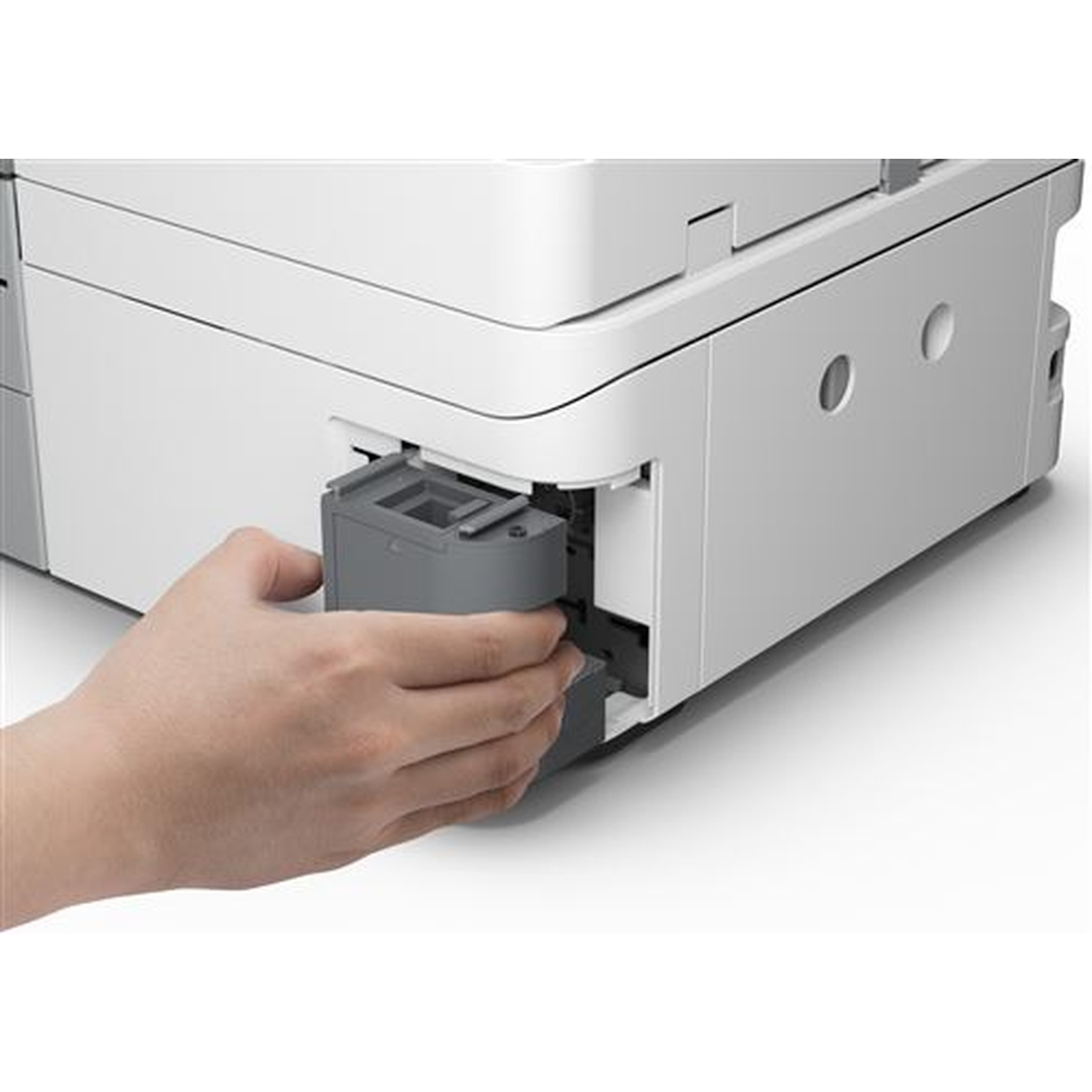 A hand inserts a gray component into a white printer. The printer has gray and white parts. The hand is fair-skinned.