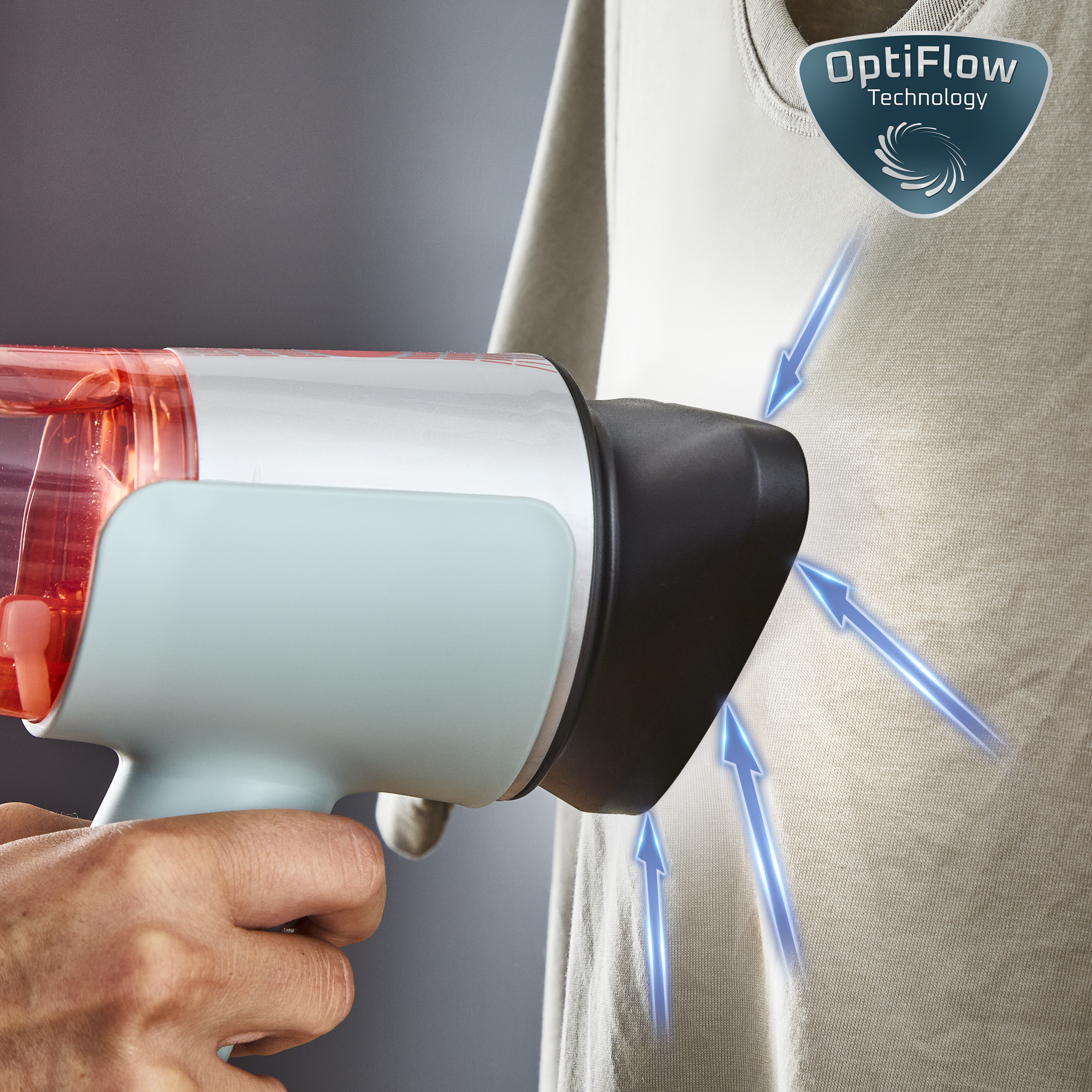 Una persona usa un dispositivo OptiFlow azul y gris en una camisa beige. Flechas indican el flujo de aire. El fondo es gris.
