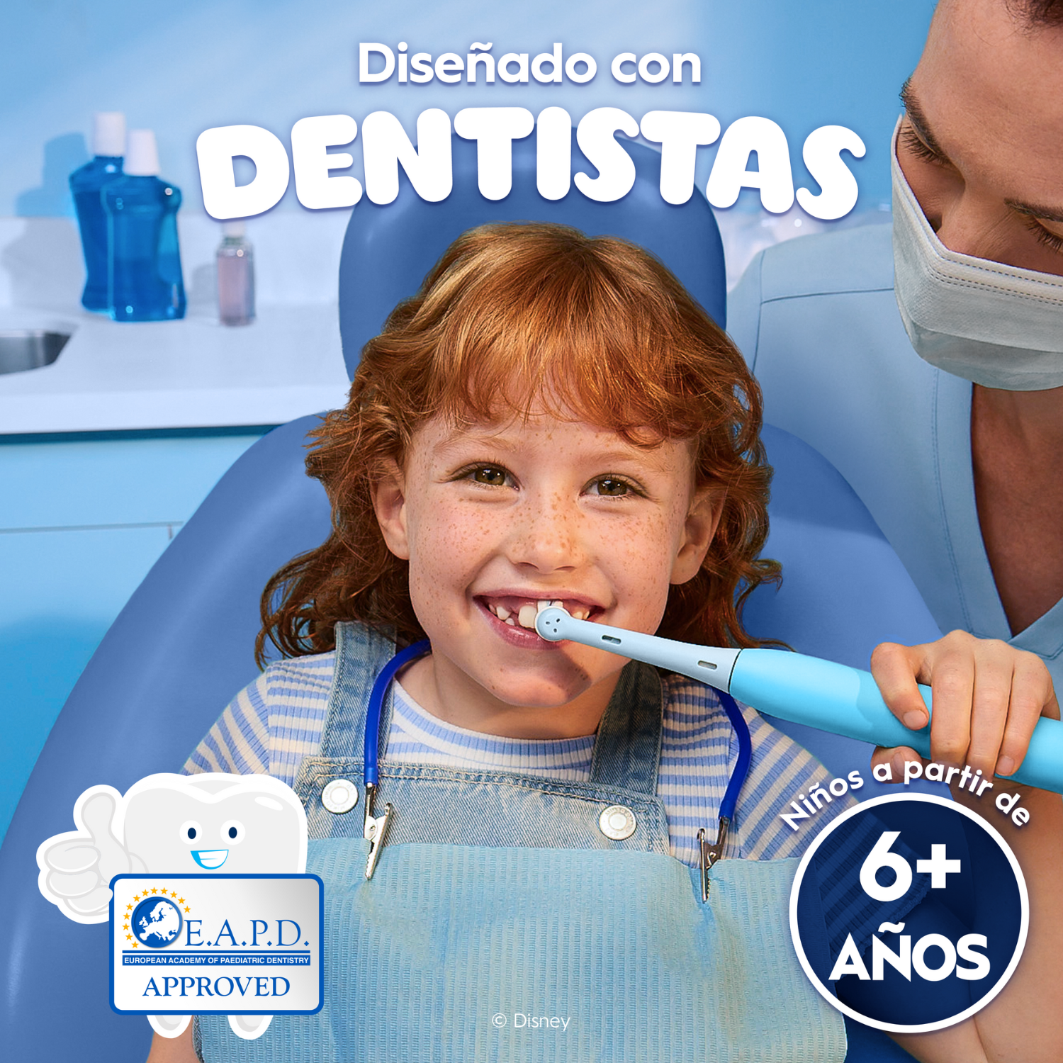 Una niña sonríe mientras un dentista le limpia los dientes con un cepillo de dientes azul. El texto dice 'Diseñado con dentistas' y '6+ años'.