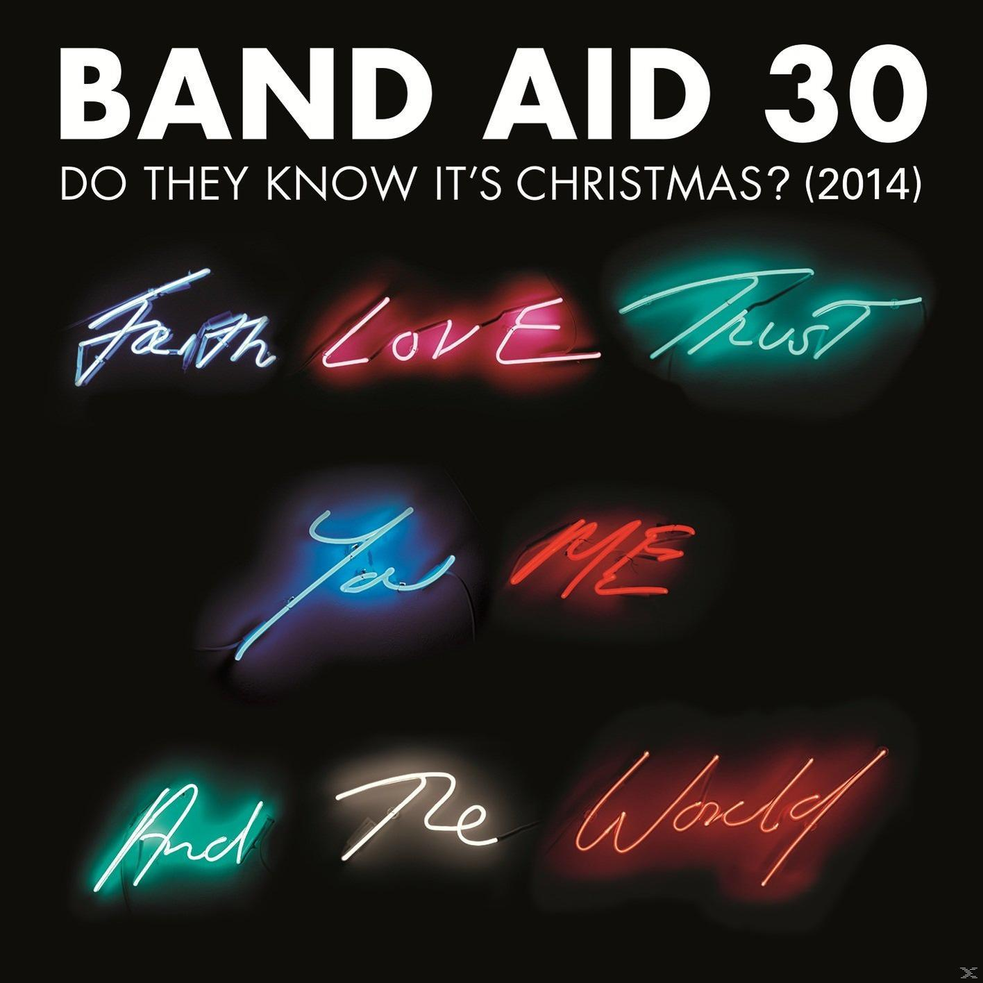 Fekete háttér neon szavakkal: Hit, Szerelem, Bizalom, Te, Én, És, A, Világ. Band Aid 30 cím, Do They Know It's Christmas? (2014).