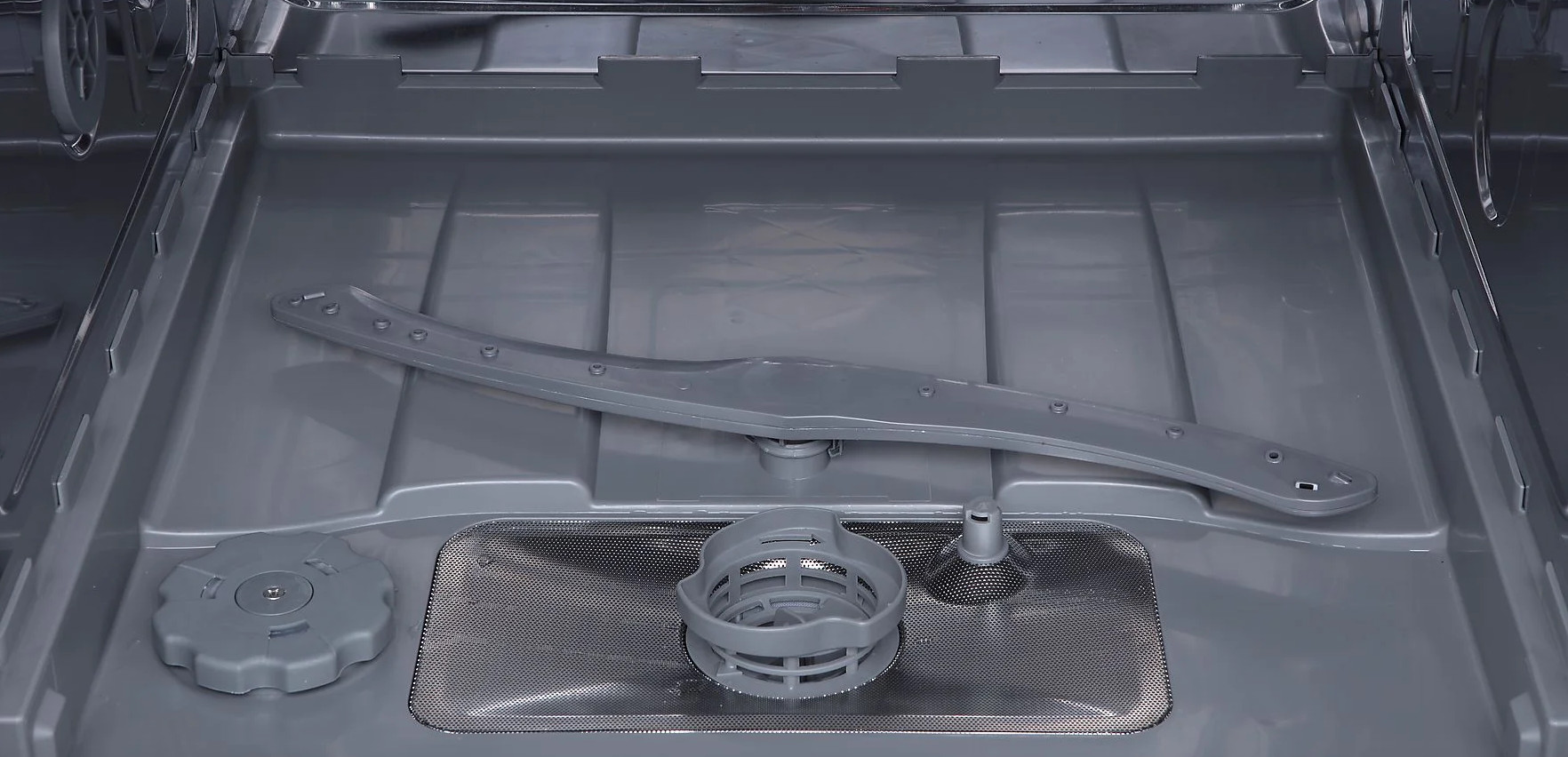 Wnętrze szarej zmywarki. Widoczne ramię obrotowe, filtr i dozownik detergentu.