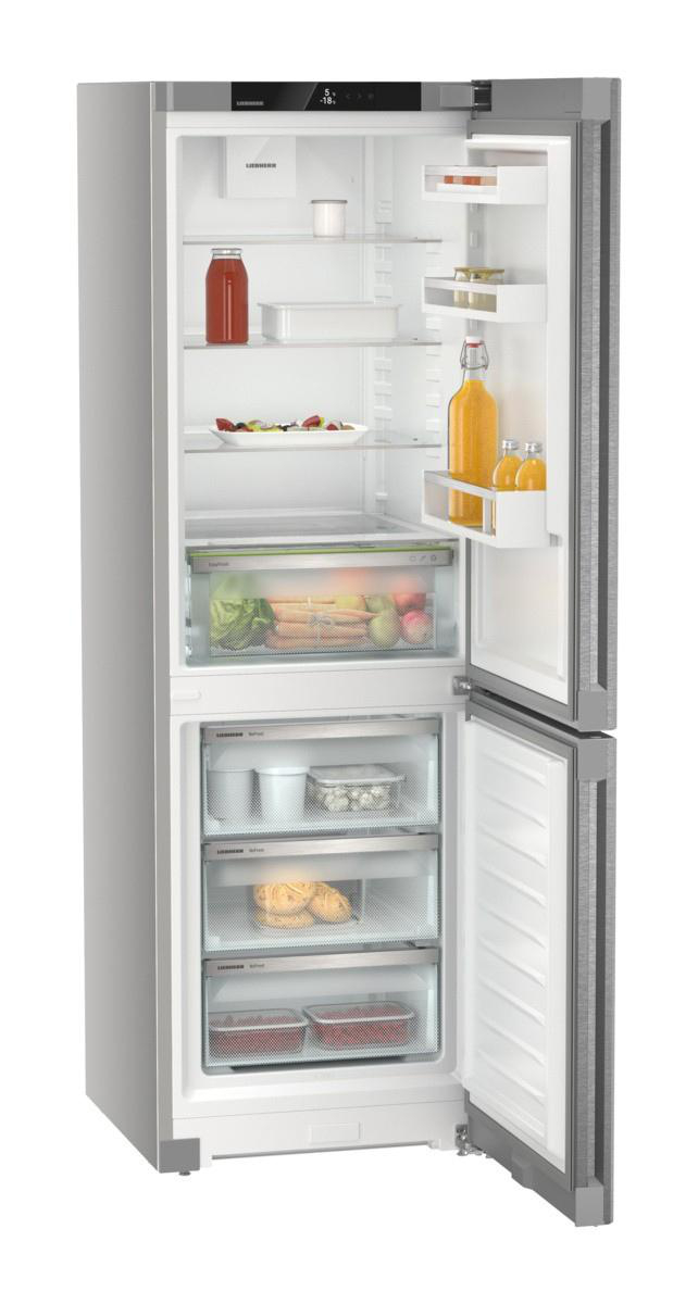 Ein Edelstahlkühlschrank ist geöffnet und zeigt Regale mit Lebensmitteln wie Saft, Gemüse und Obst.