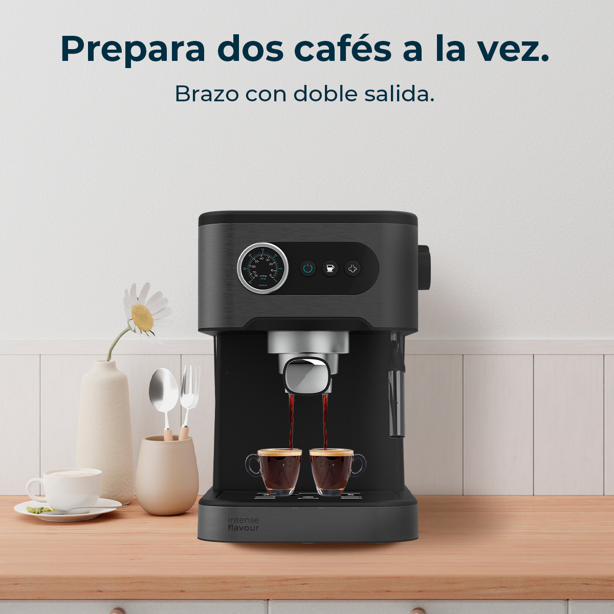 Una máquina de espresso negra preparando dos cafés. Las tazas están sobre una superficie de madera. Un jarrón con una flor y una taza están al lado.