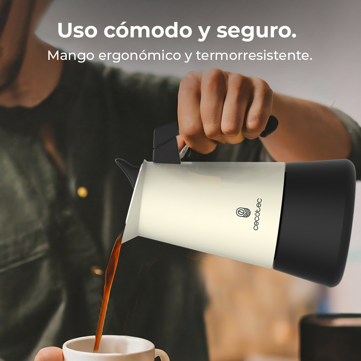Una persona vierte café de una cafetera blanca y negra en una taza blanca. La cafetera tiene un asa negra.
