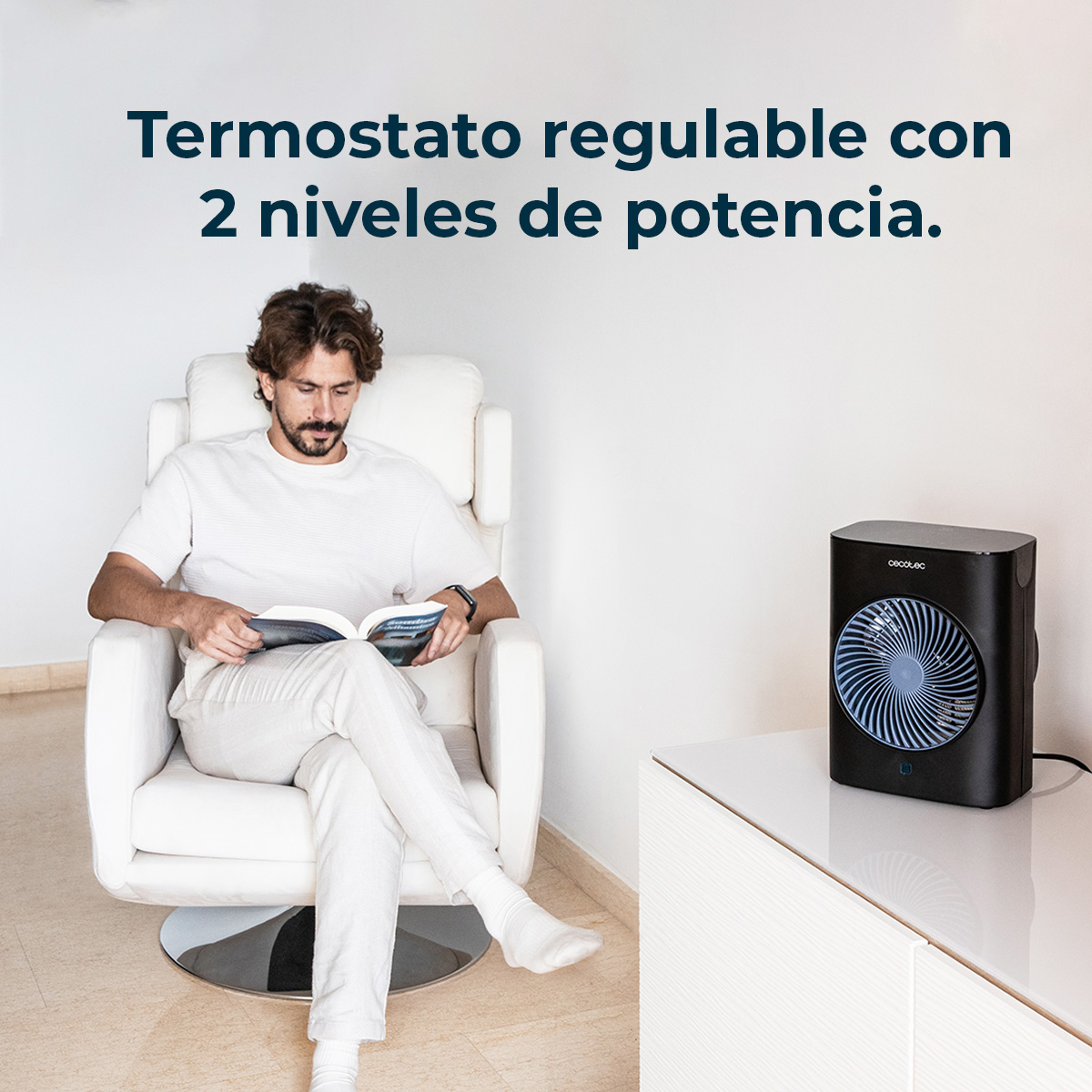 Hombre lee un libro en una silla blanca cerca de un ventilador negro. El texto superior dice termostato ajustable con 2 niveles de potencia.