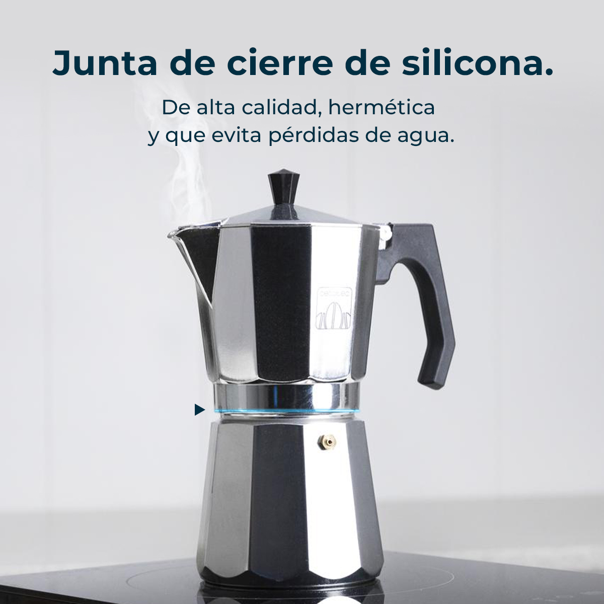 Una cafetera plateada y negra está sobre una estufa negra. El vapor se eleva desde la parte superior. El texto dice 'sello de silicona'.