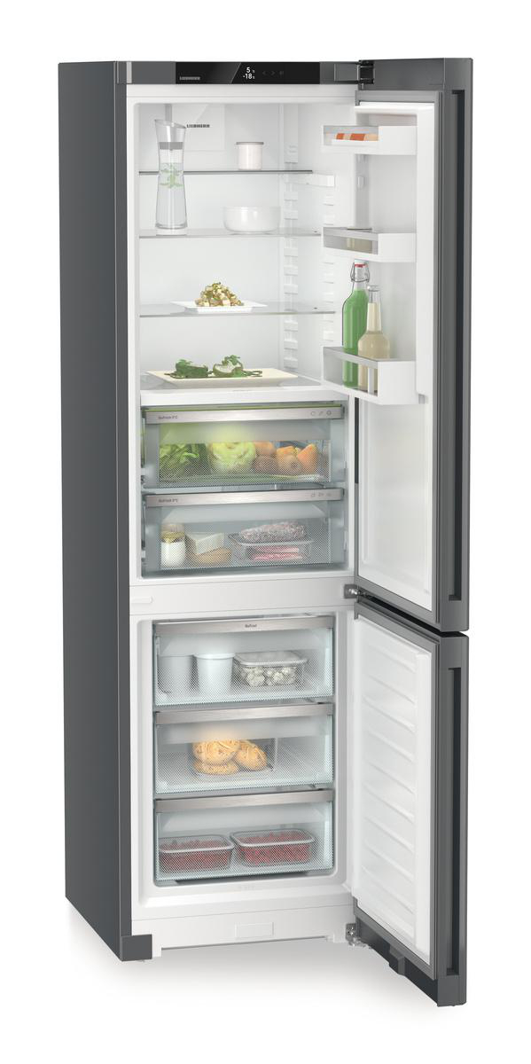 Ein moderner Kühlschrank mit offener Tür. Innen gibt es Regale mit Lebensmitteln wie Gemüse, Obst und Flaschen, ordentlich angeordnet.
