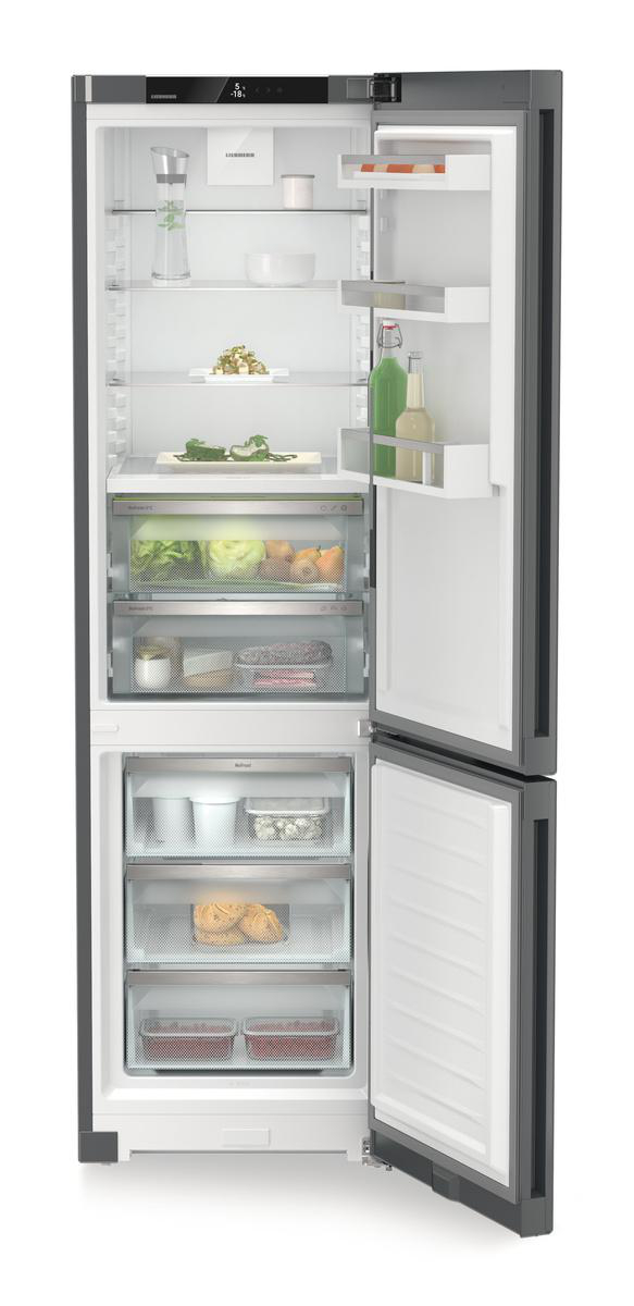 Offener Kühlschrank mit verschiedenen Lebensmitteln auf Regalen und Schubladen. Enthält Obst, Gemüse und Flaschen.