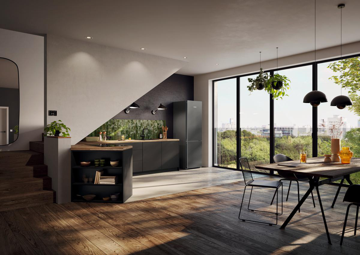 Moderne Küche mit dunklen Schränken, Kühlschrank und Essbereich mit großen Fenstern und Blick auf grüne Landschaft.