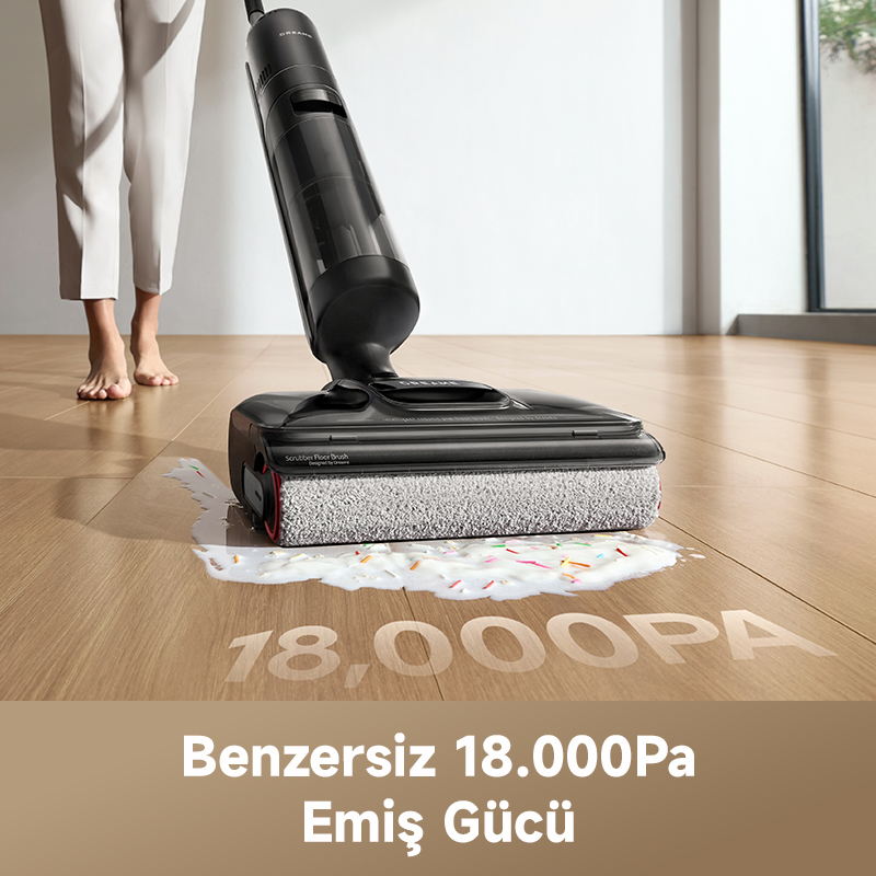 Bir kişi, siyah bir elektrikli süpürge ile ahşap bir zemini süpürüyor. Zeminde renkli serpmelerle bir dökülme var. Metin 18.000Pa diyor.