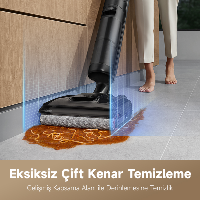Siyah bir elektrikli süpürge, gri fayanslı bir zeminde dökülen spagettiyi temizliyor. Beyaz pantolonlu bir kişi yakındadır.