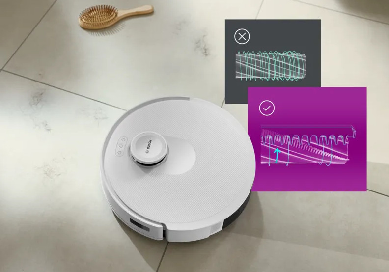 Biały robot odkurzający na kafelkach, drewniana szczotka i dwa schematy. Jeden pokazuje, jak powinno wyglądać.