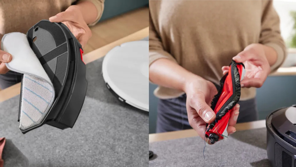 Ręce trzymające części robota odkurzającego. Jeden pokazuje nakładkę czyszczącą, drugi czerwoną szczotkę. Z tyłu biały odkurzacz.