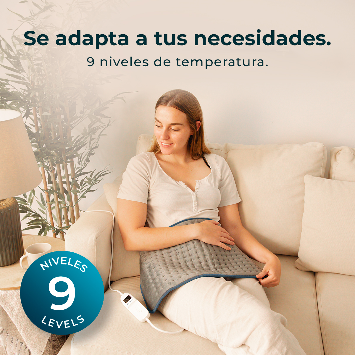 Mujer en sofá con almohadilla térmica. Texto: 'Se adapta a tus necesidades' y '9 niveles de temperatura'.
