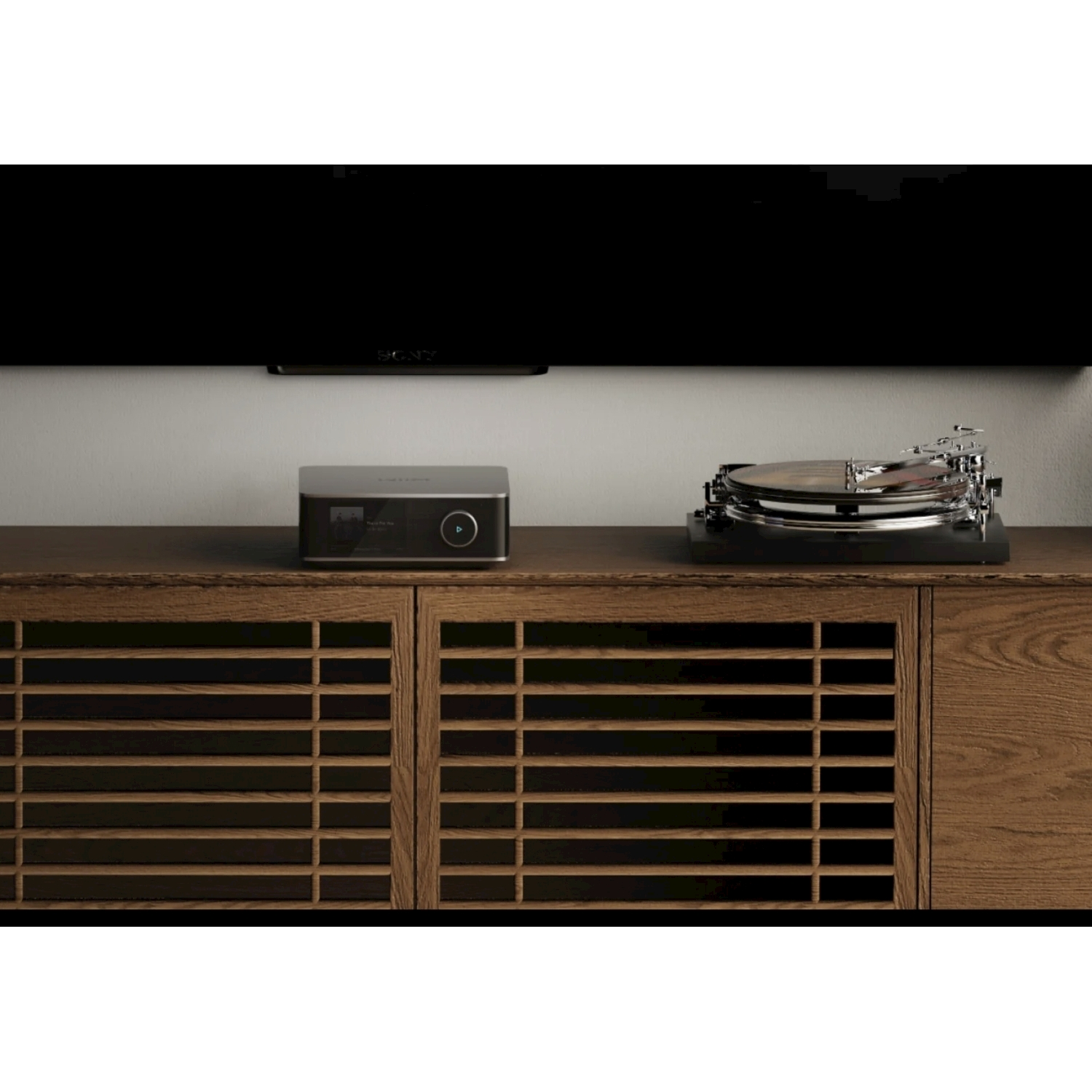 Un mobile in legno con giradischi e lettore multimediale sopra, una TV nera sopra. Il mobile ha ante a lamelle.