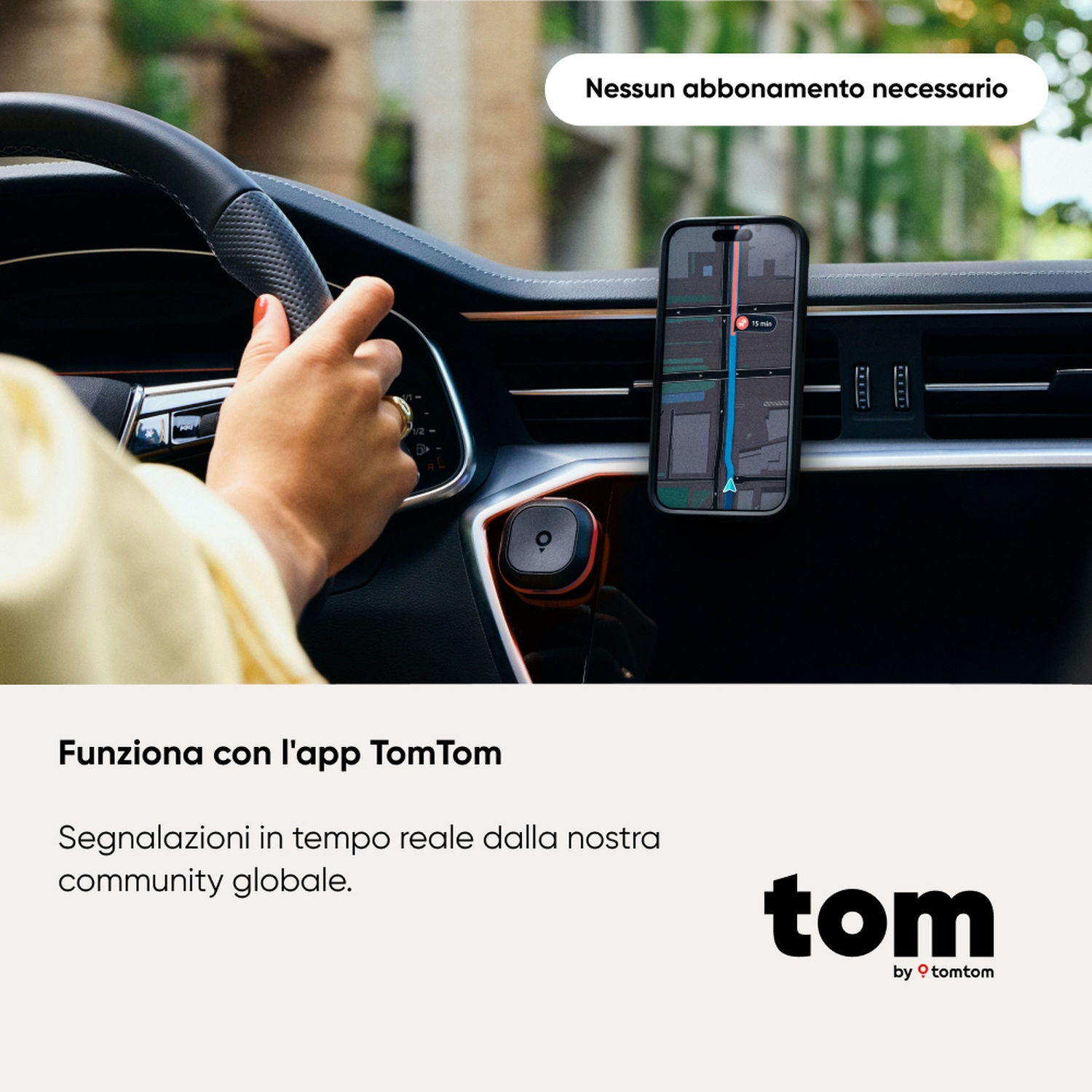 Una persona guida, tenendo il volante. Un telefono con mappa è montato sul cruscotto. Logo TomTom in basso.