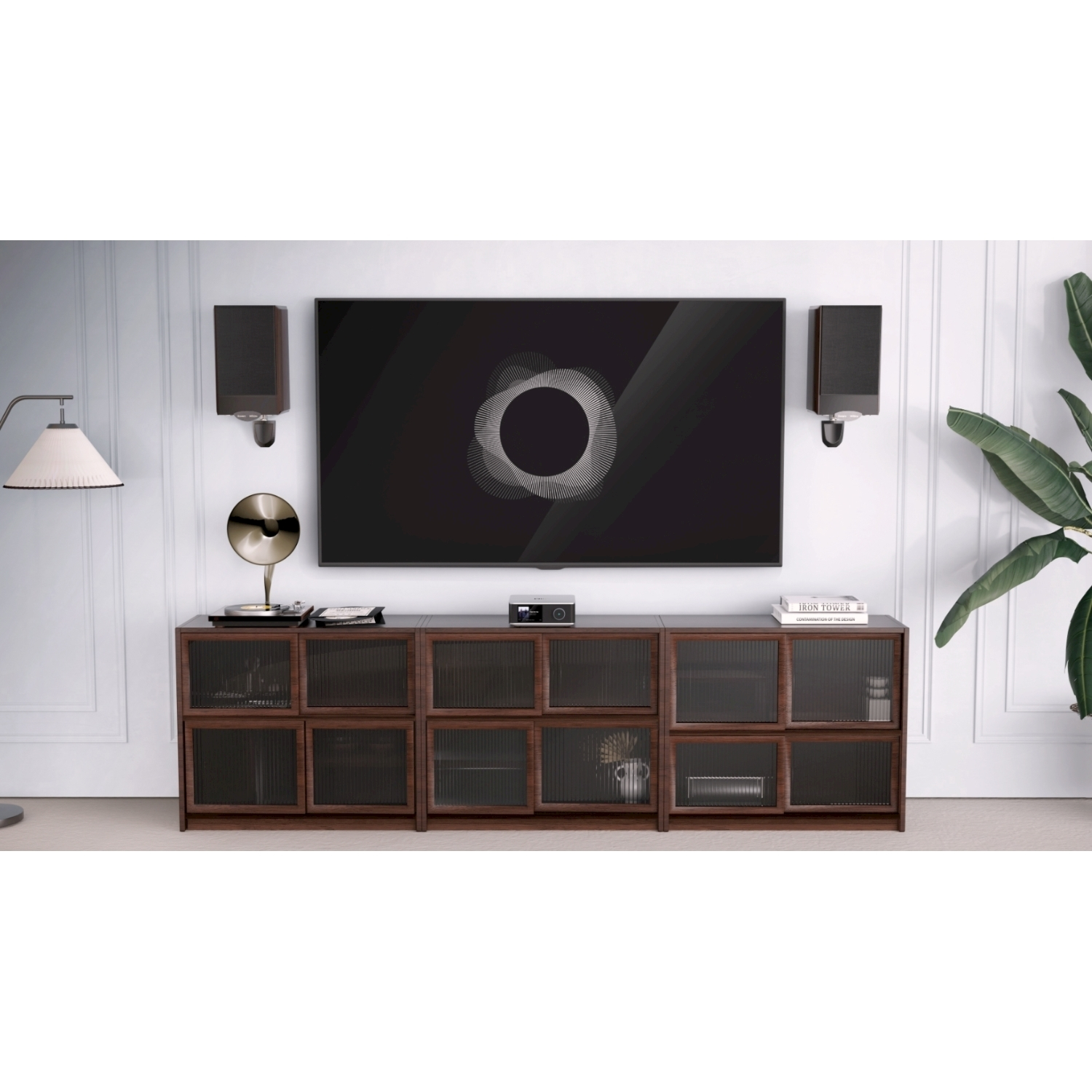 Soggiorno con TV, impianto audio e mobile in legno. Altoparlanti a parete. Una pianta a destra.