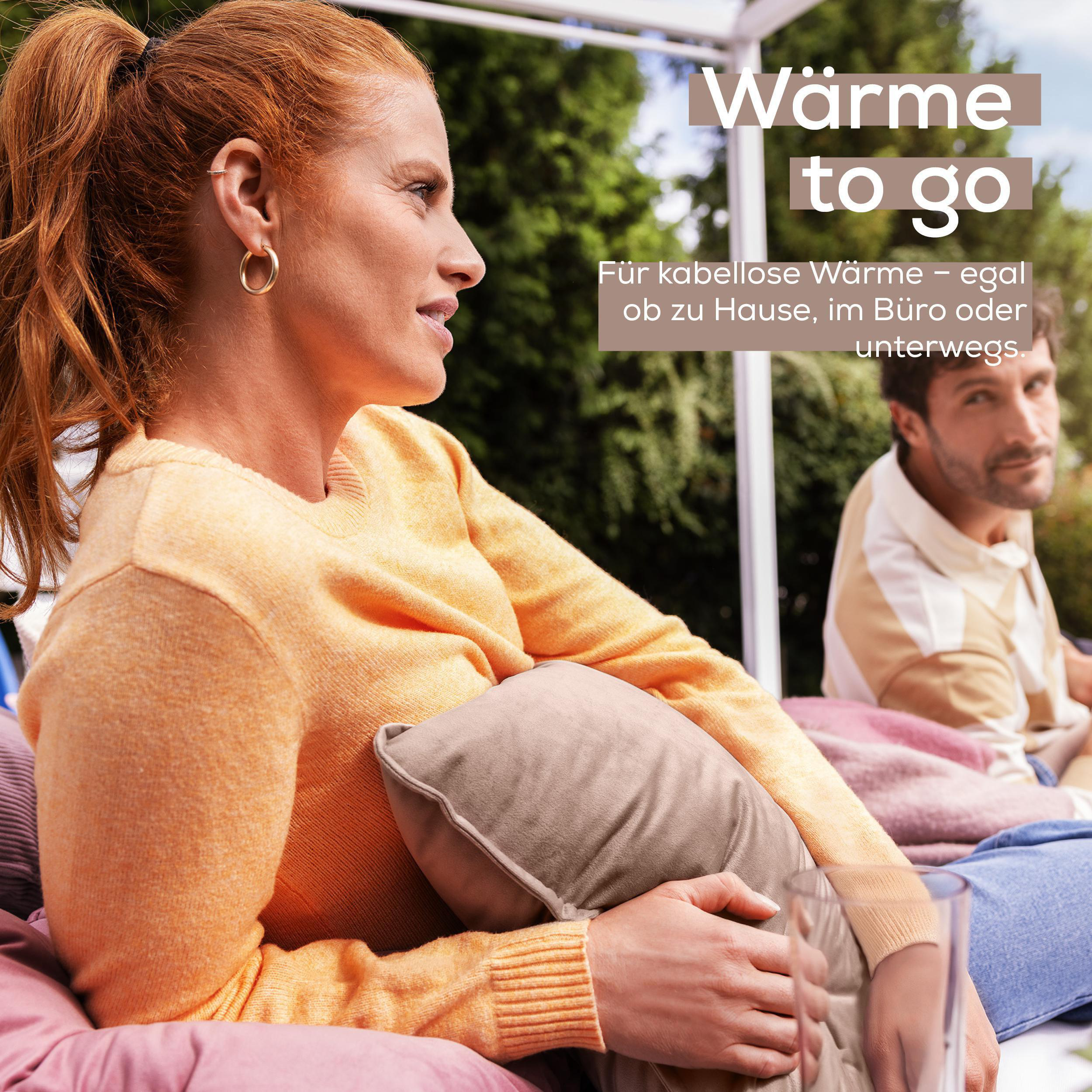 Frau mit Kissen, Mann im Hintergrund. Text 'Wärme to go' sichtbar.