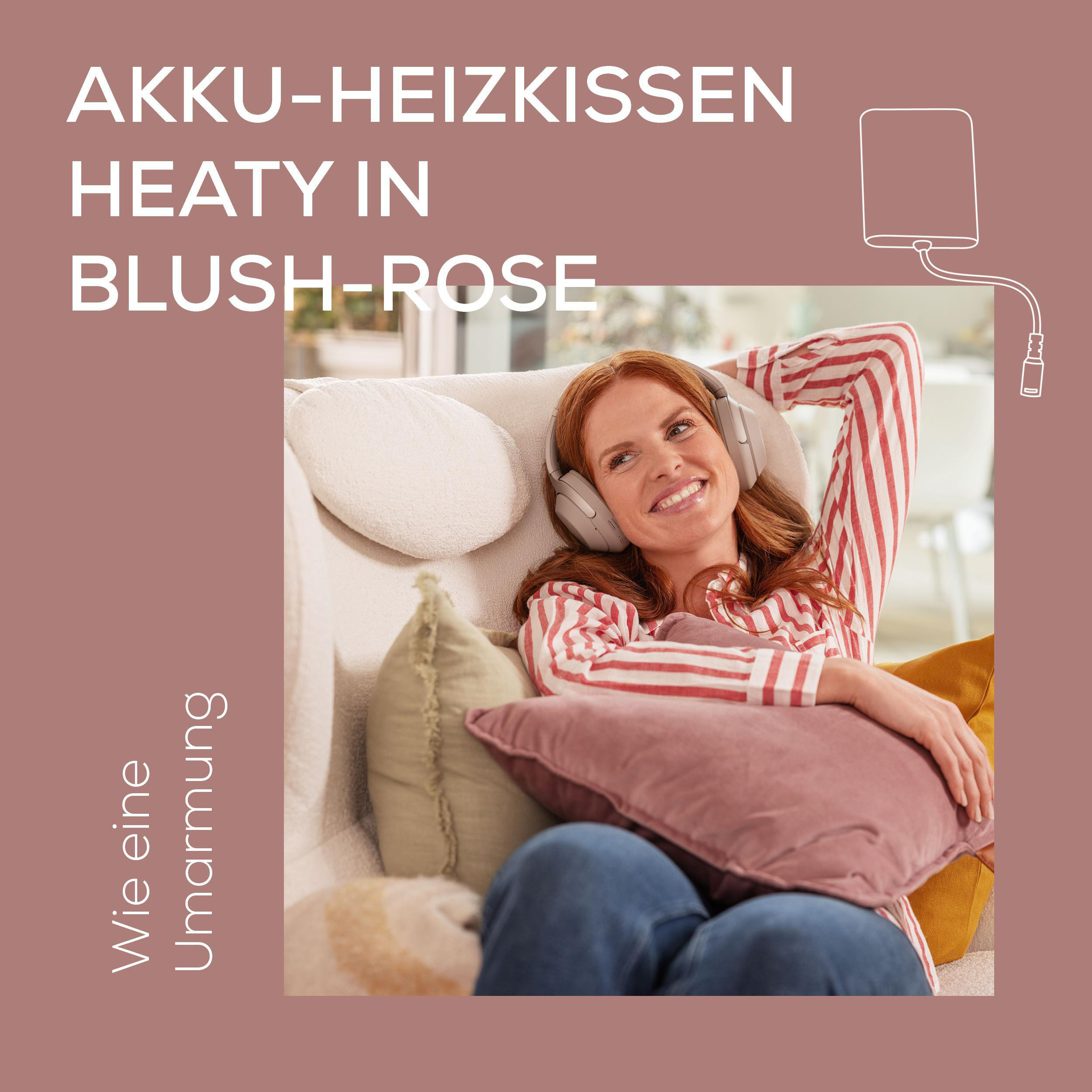 Frau auf Couch mit Kopfhörern, lächelnd, Hand am Kopf. Oben Text: Akku-Heizkissen Heaty in Blush-Rose.