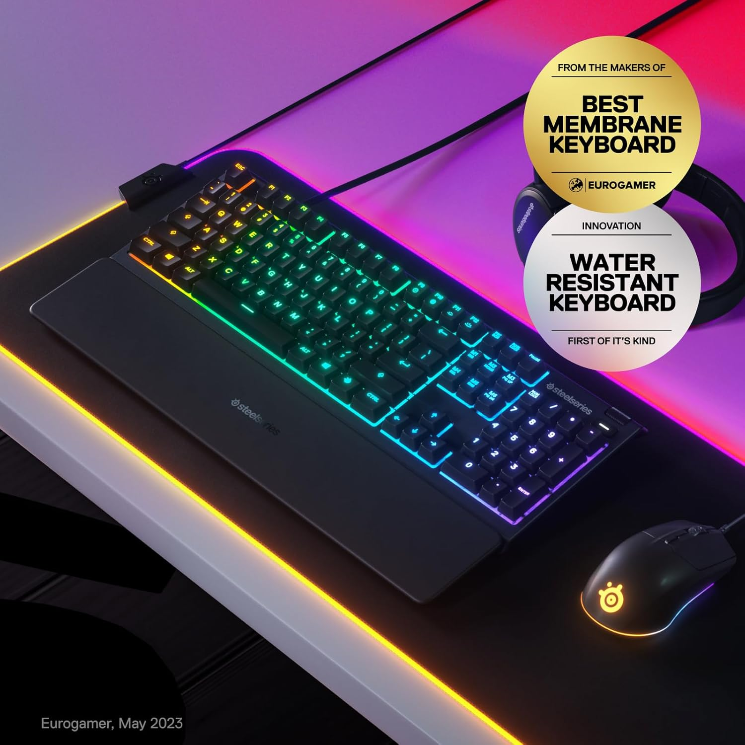 Ein Gaming-Setup mit hintergrundbeleuchteter Tastatur, Maus und Mauspad. Auszeichnungen für beste Membran- und wasserfeste Tastatur sichtbar.