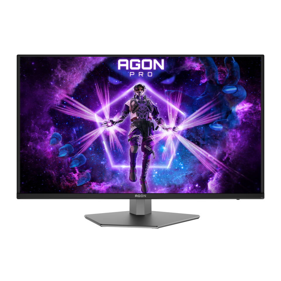 Egy gamer monitor egy futurisztikus öltözékes karaktert jelenít meg lila energiasugarakkal, kozmikus háttérrel és AGON PRO logóval.