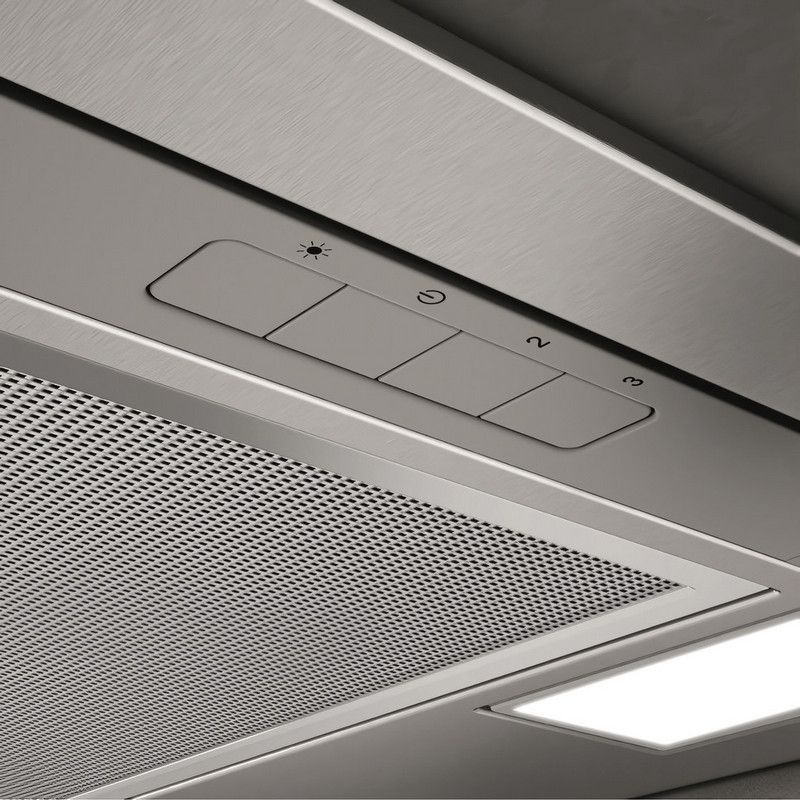 A páraelszívó vezérlőpaneljének közeli képe. Van rajta gomb a világításhoz, a bekapcsoláshoz és a ventilátor sebességéhez. Egy fémháló és egy lámpa látható.