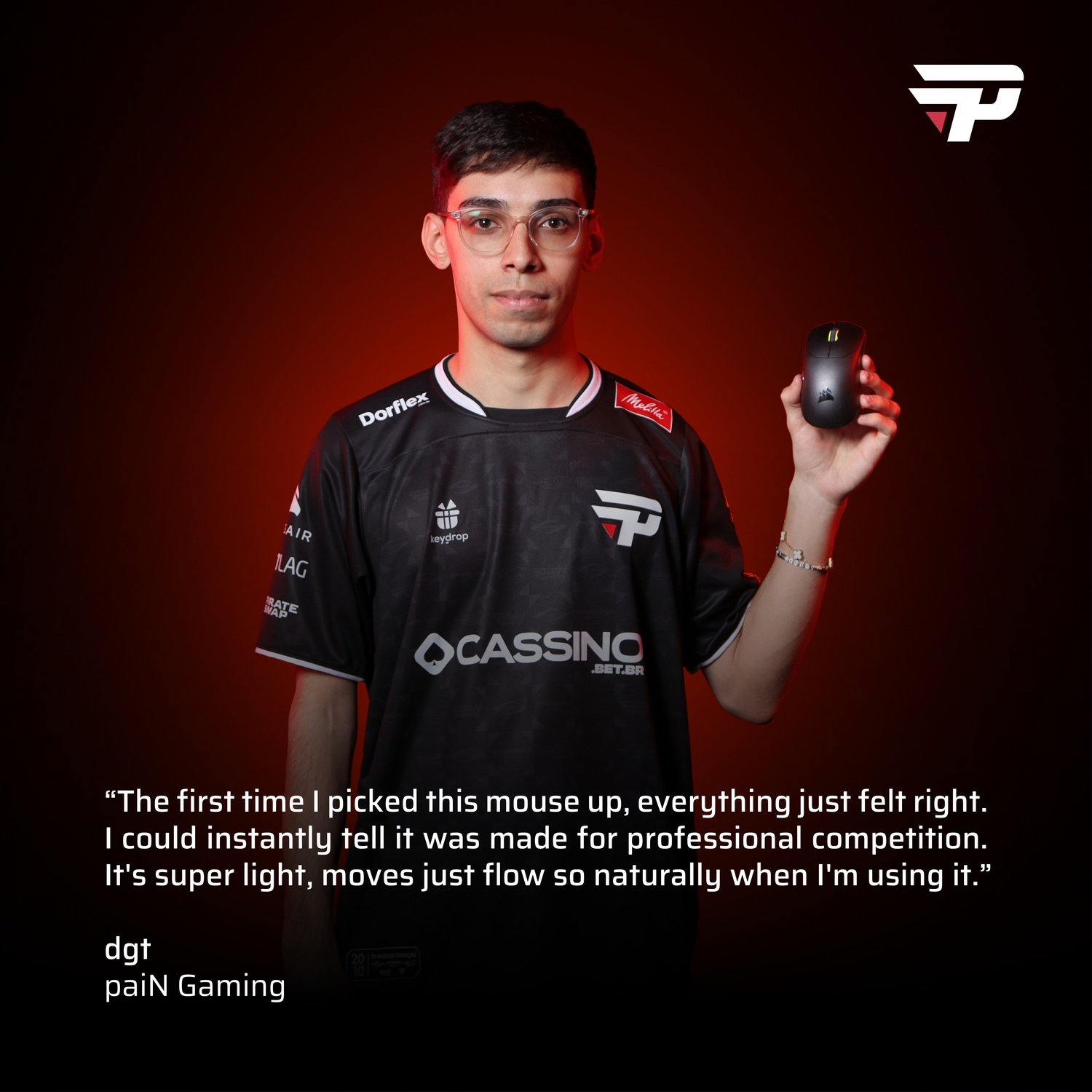 Man holds a black mouse. He wears glasses and a black jersey with logos. Red background with a white and red logo.