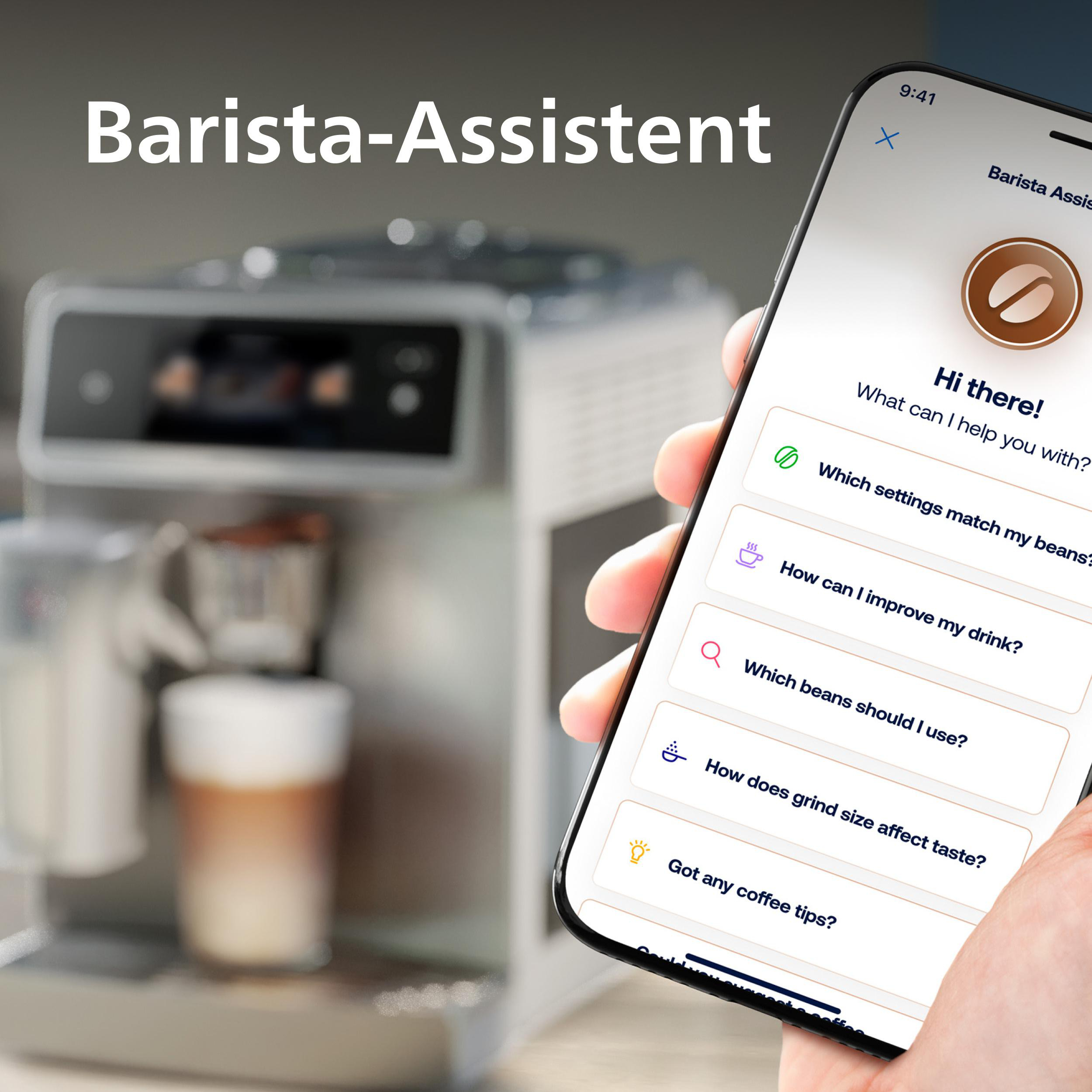 Eine Hand hält ein Telefon mit einer Barista-Assistent-App. Im Hintergrund ist eine Kaffeemaschine zu sehen.