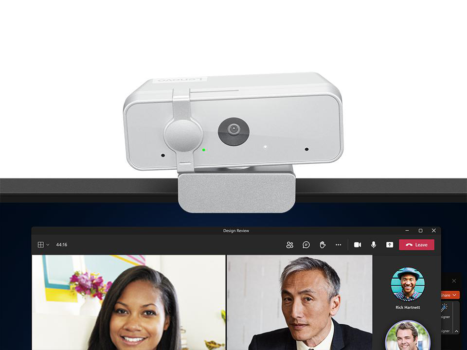 Webcam auf einem Monitor, der einen Videoanruf zeigt. Drei Personen sind im Anruf. Die Webcam ist von der Marke Lenovo.
