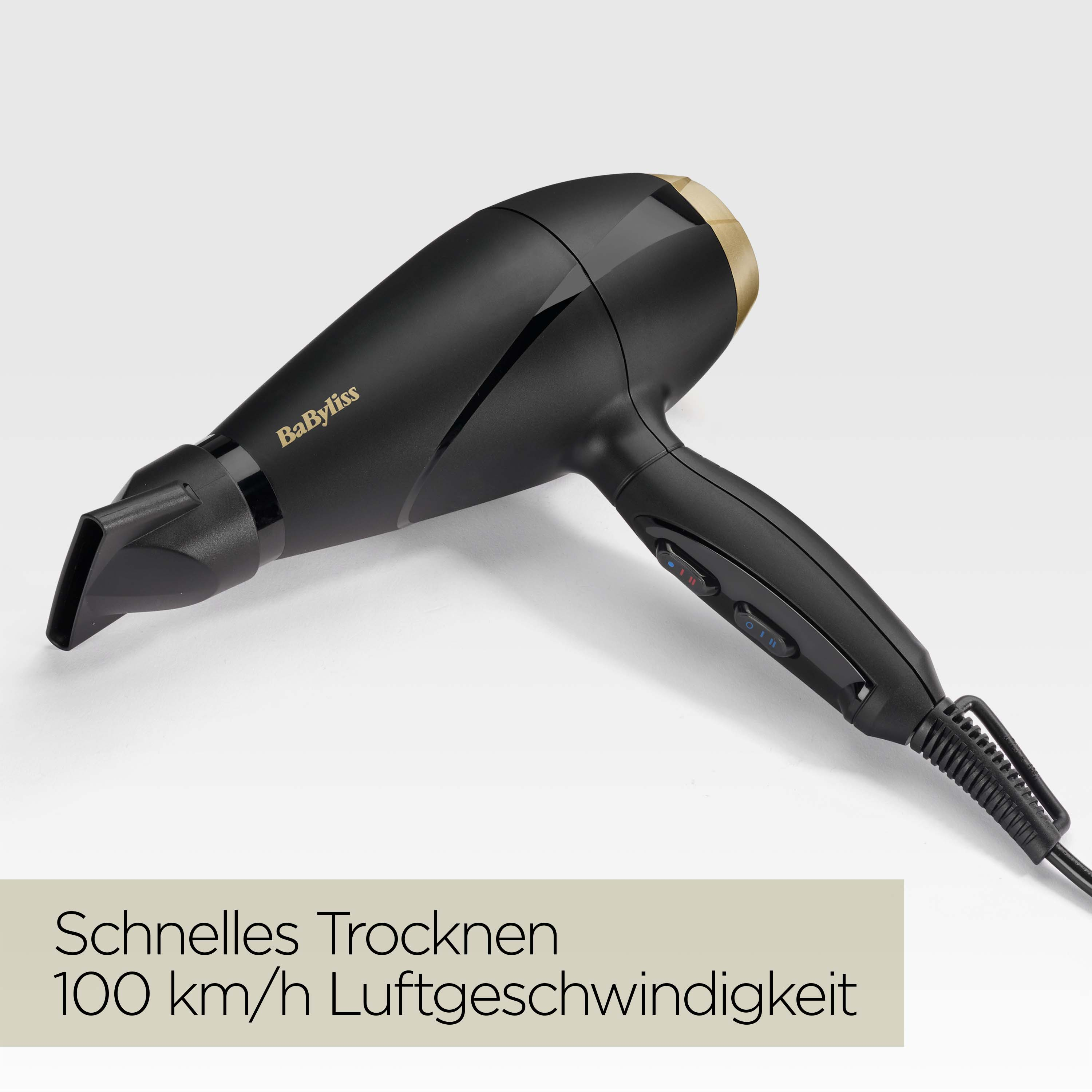 Schwarzer Babyliss-Haartrockner. Goldakzente. Text unten: Schnellles Trocknen 100 km/h Luftgeschwindigkeit.