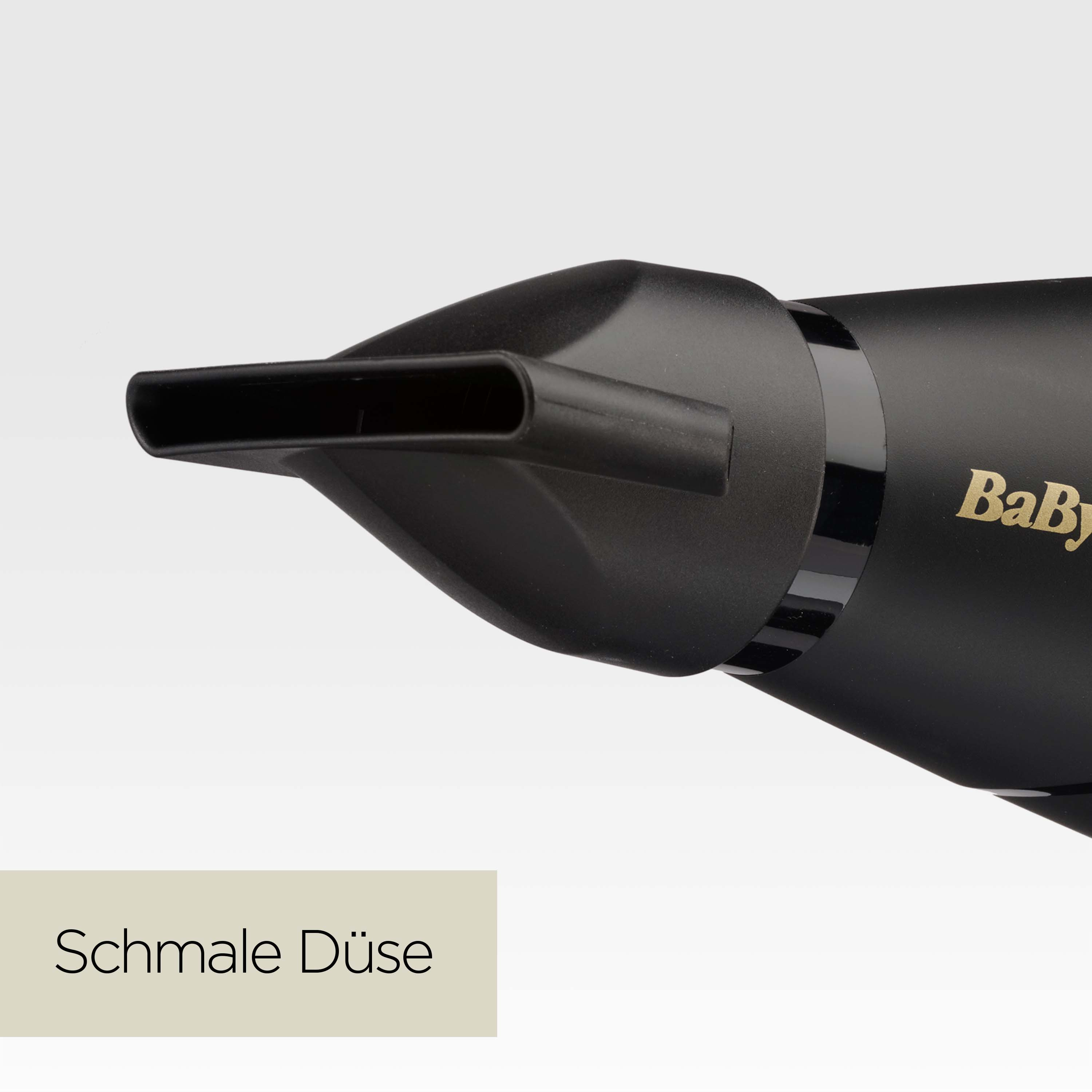 Nahaufnahme eines schwarzen Haartrockners mit schmaler Düse. Das Wort „Baby“ ist sichtbar. Text unten lautet „Schmale Düse“.