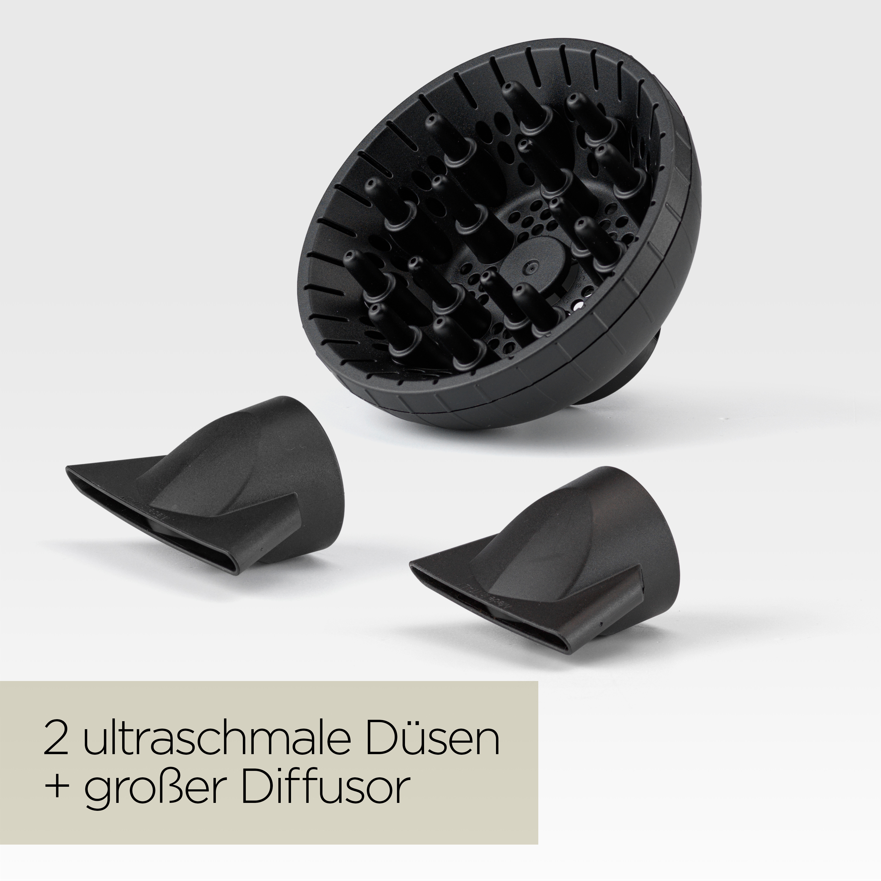Schwarze Haartrockneraufsätze auf weißem Hintergrund. Enthält einen Diffusor und zwei Düsen.