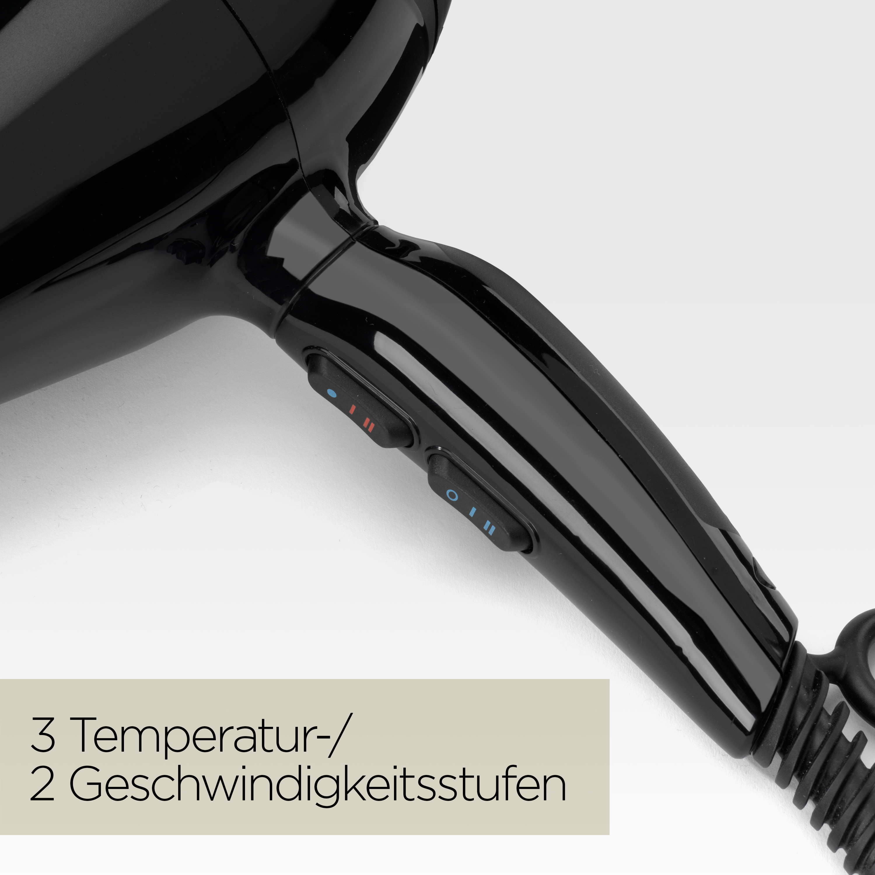 Nahaufnahme eines schwarzen Haartrockners mit zwei Bedientasten. Der Hintergrund ist weiß. Text unten: 3 Temperatur- und 2 Geschwindigkeitseinstellungen.