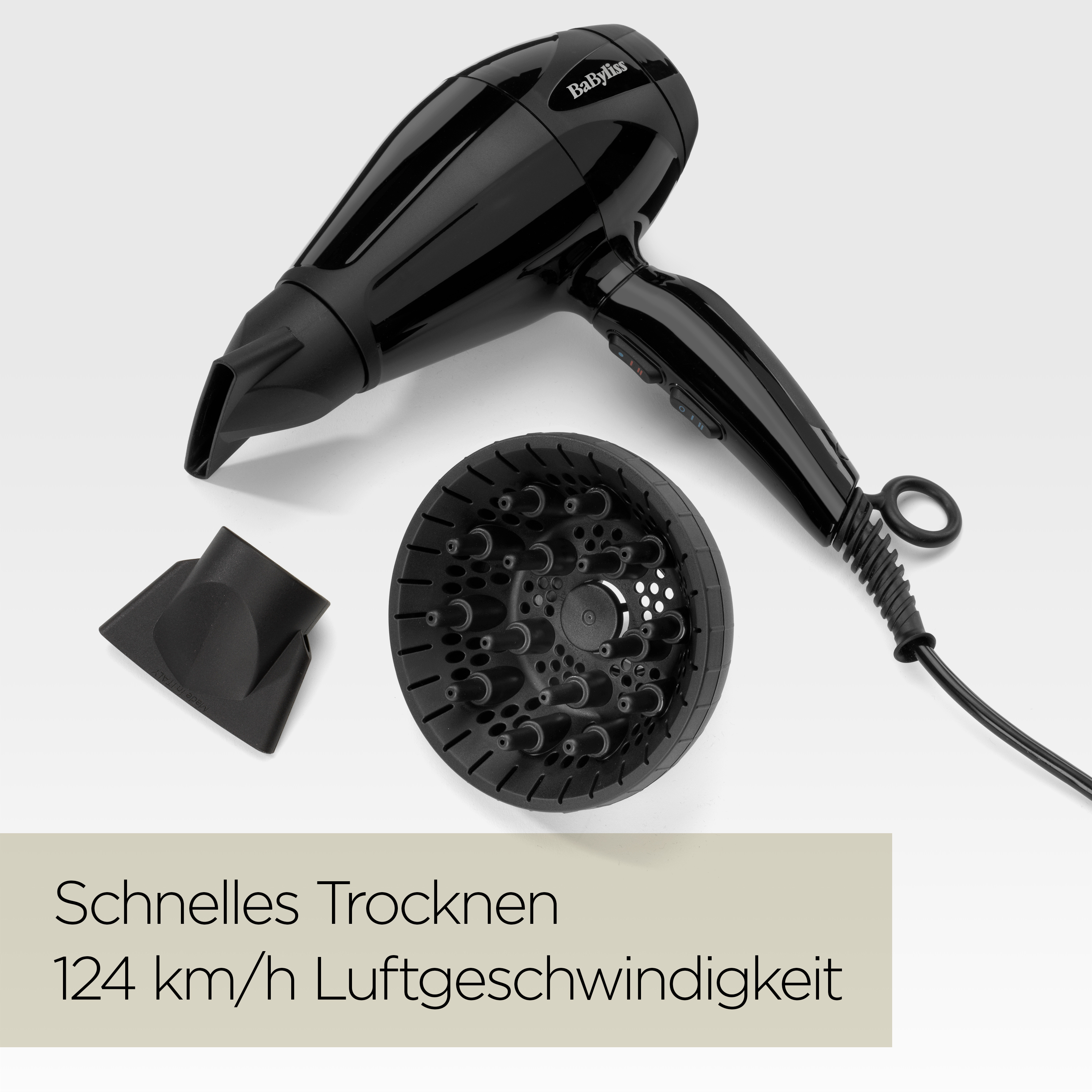 Schwarzer Haartrockner mit Aufsätzen, Diffusor und Düse auf weißem Grund. Text unten sagt Trocknungsgeschwindigkeit.