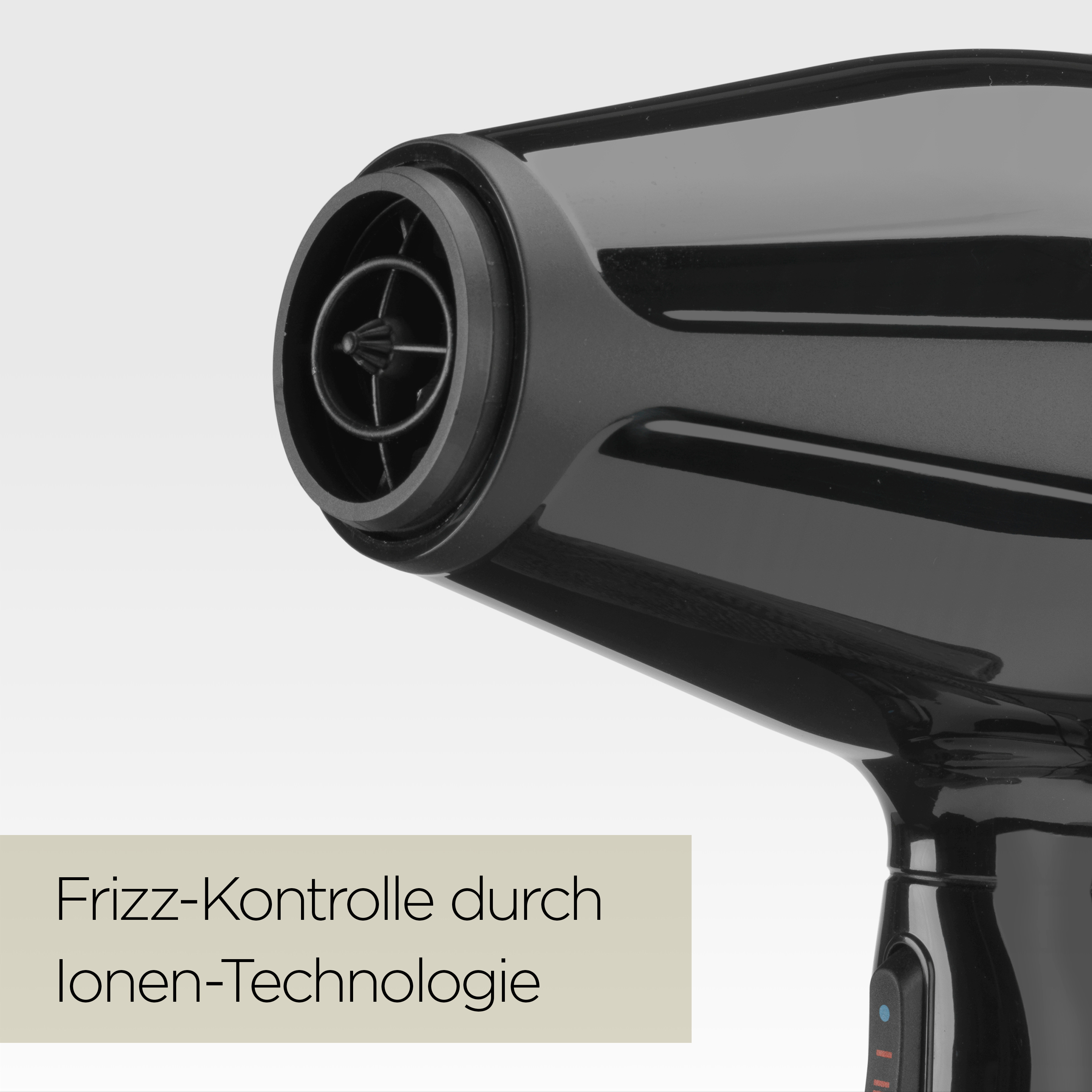 Nahaufnahme eines schwarzen Haartrockners. Er hat eine Düse mit einem Grill. Der Text lautet 'Frizz-Kontrolle durch Ionen-Technologie'.