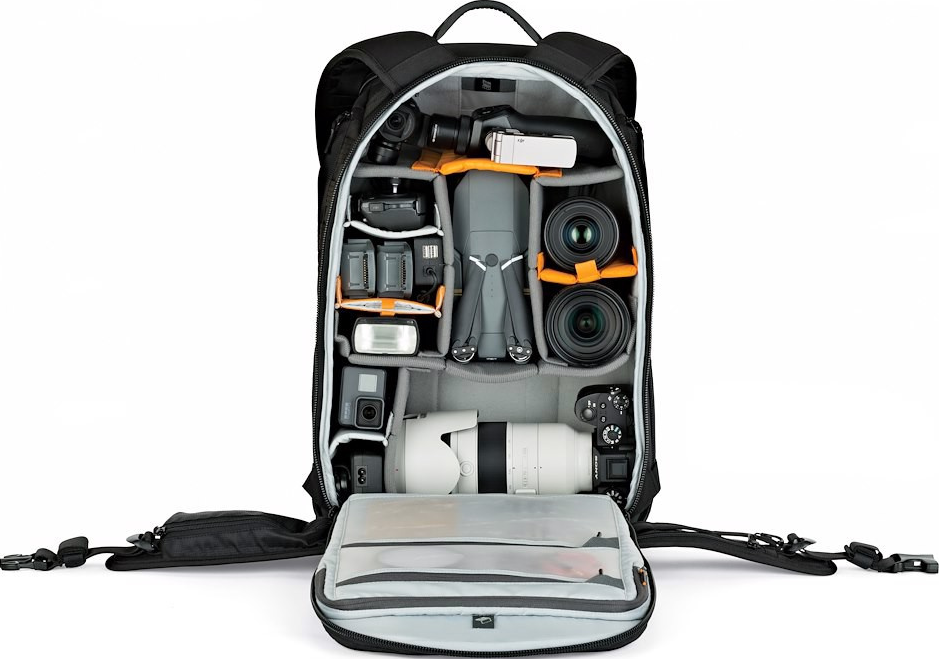 Zaino nero per fotocamera aperto, pieno di attrezzatura fotografica: obiettivi, drone, action cam, flash, batterie e fotocamera.