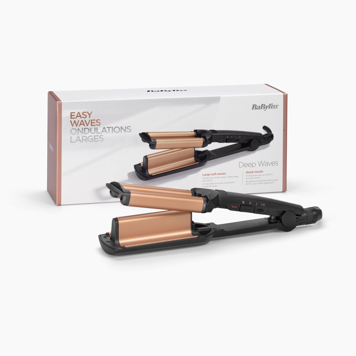 Ein BaByliss-Haarwellengerät und seine Schachtel liegen auf einer weißen Oberfläche. Das Wellengerät ist schwarz und goldfarben, die Schachtel weiß und rosa.