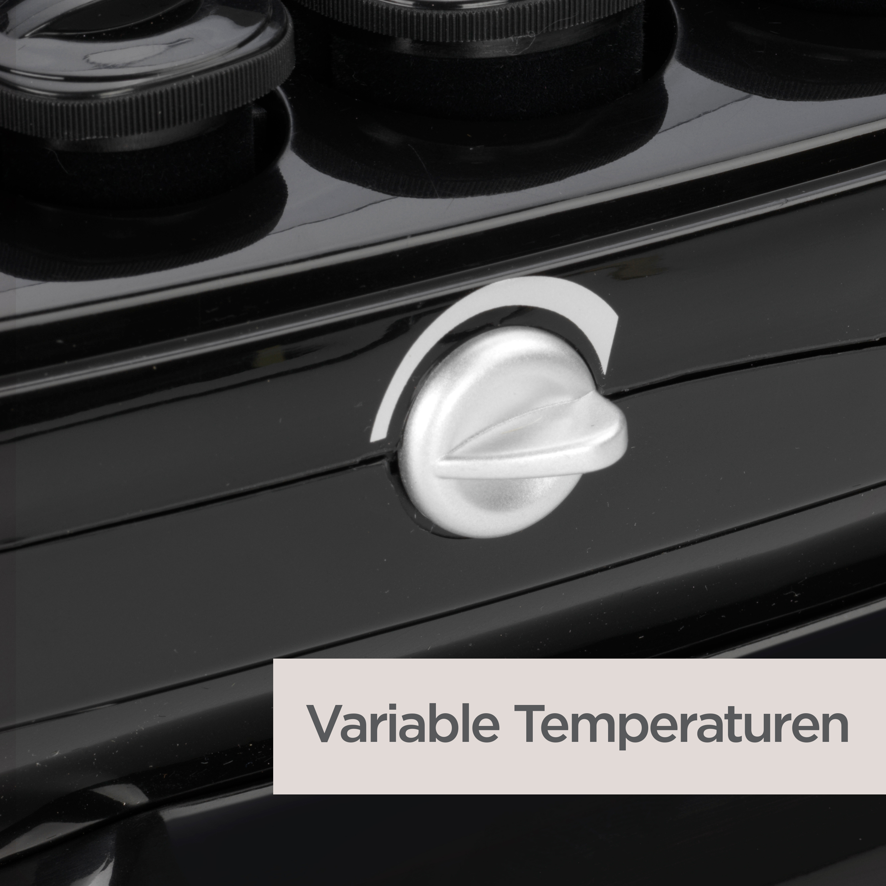 Nahaufnahme eines schwarzen Geräts mit silbernem Drehknopf. Der Knopf steht vor einer weißen Markierung. Text: 'Variable Temperaturen'.