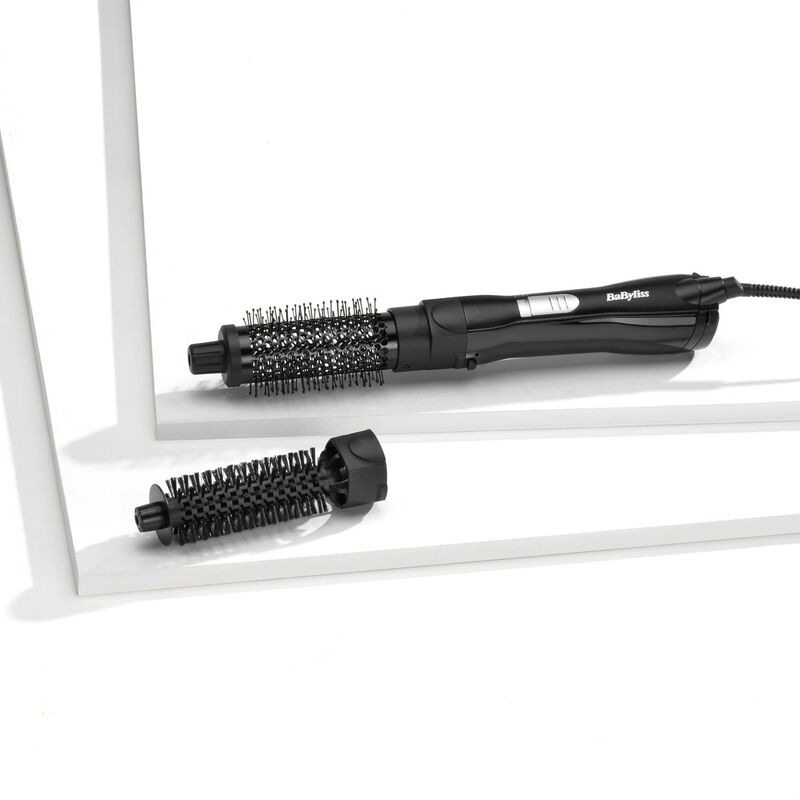 Eine schwarze Babyliss-Haarstylingbürste mit abnehmbarem Bürstenkopf, ausgestellt auf einer weißen Oberfläche. Die Bürste hat ein Kabel.