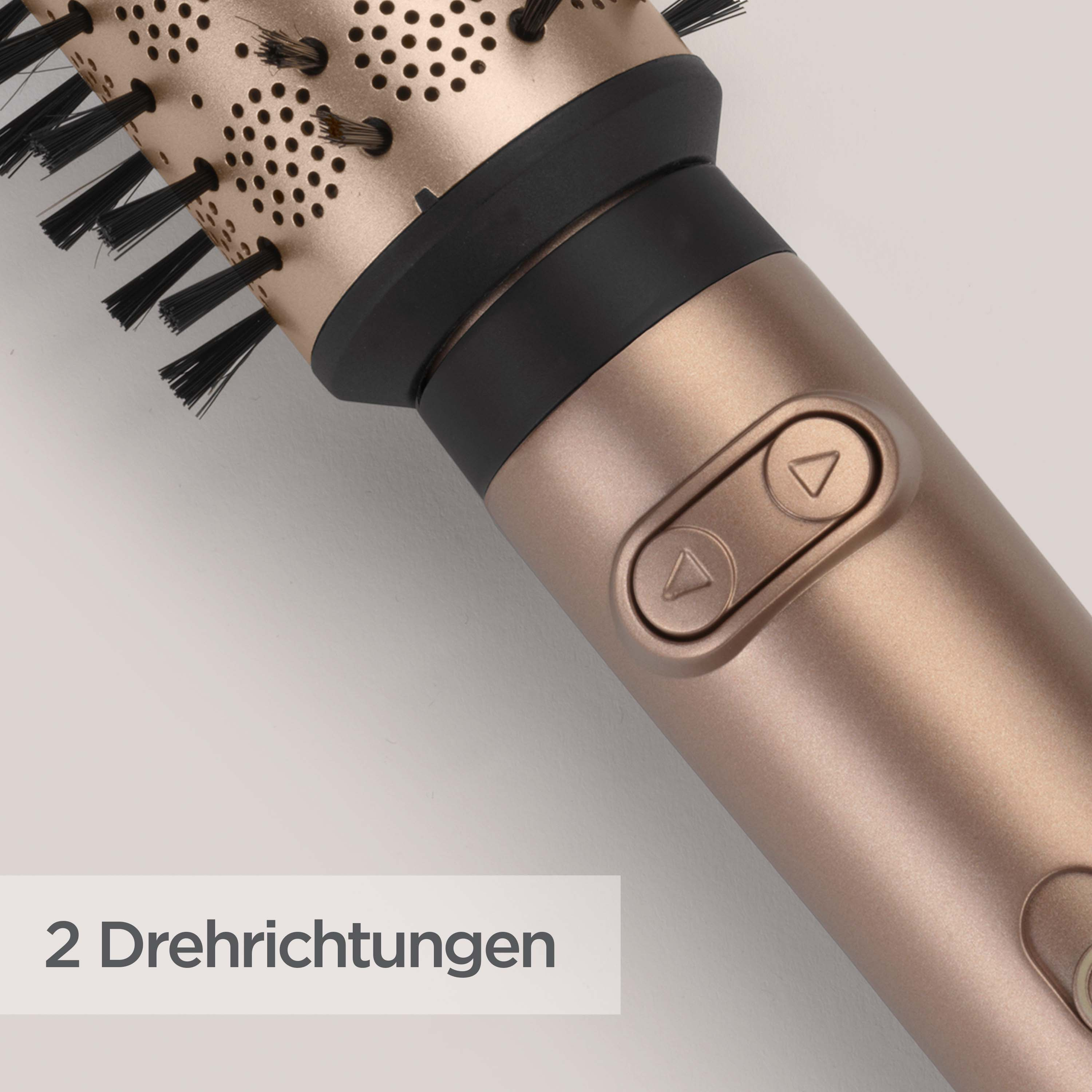 Nahaufnahme einer goldenen Haarbürste mit schwarzen Borsten. Knöpfe und Text auf der Seite. Weißer Hintergrund.