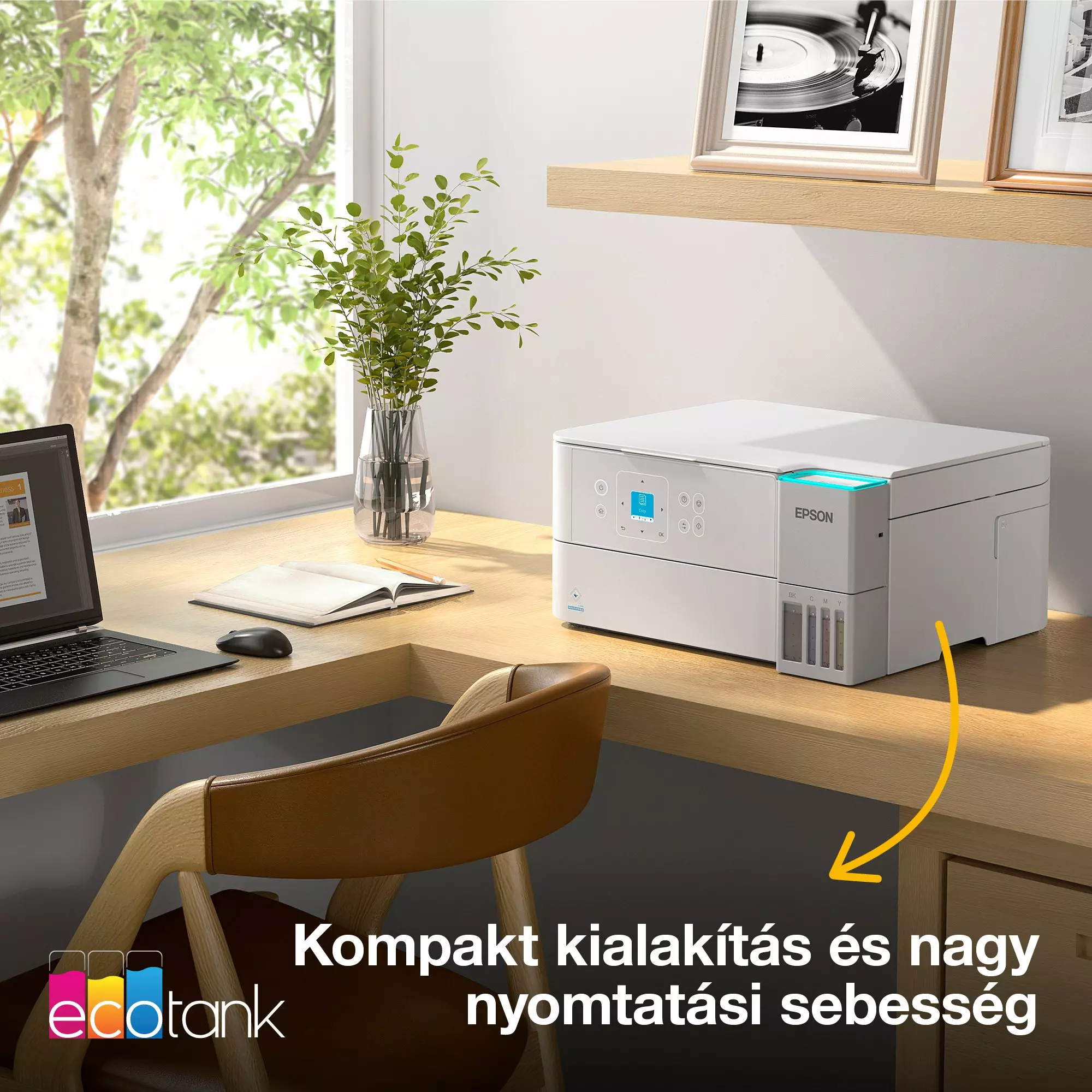Fehér nyomtató faasztalon, laptop, szék, nyitott könyv, fa a háttérben.