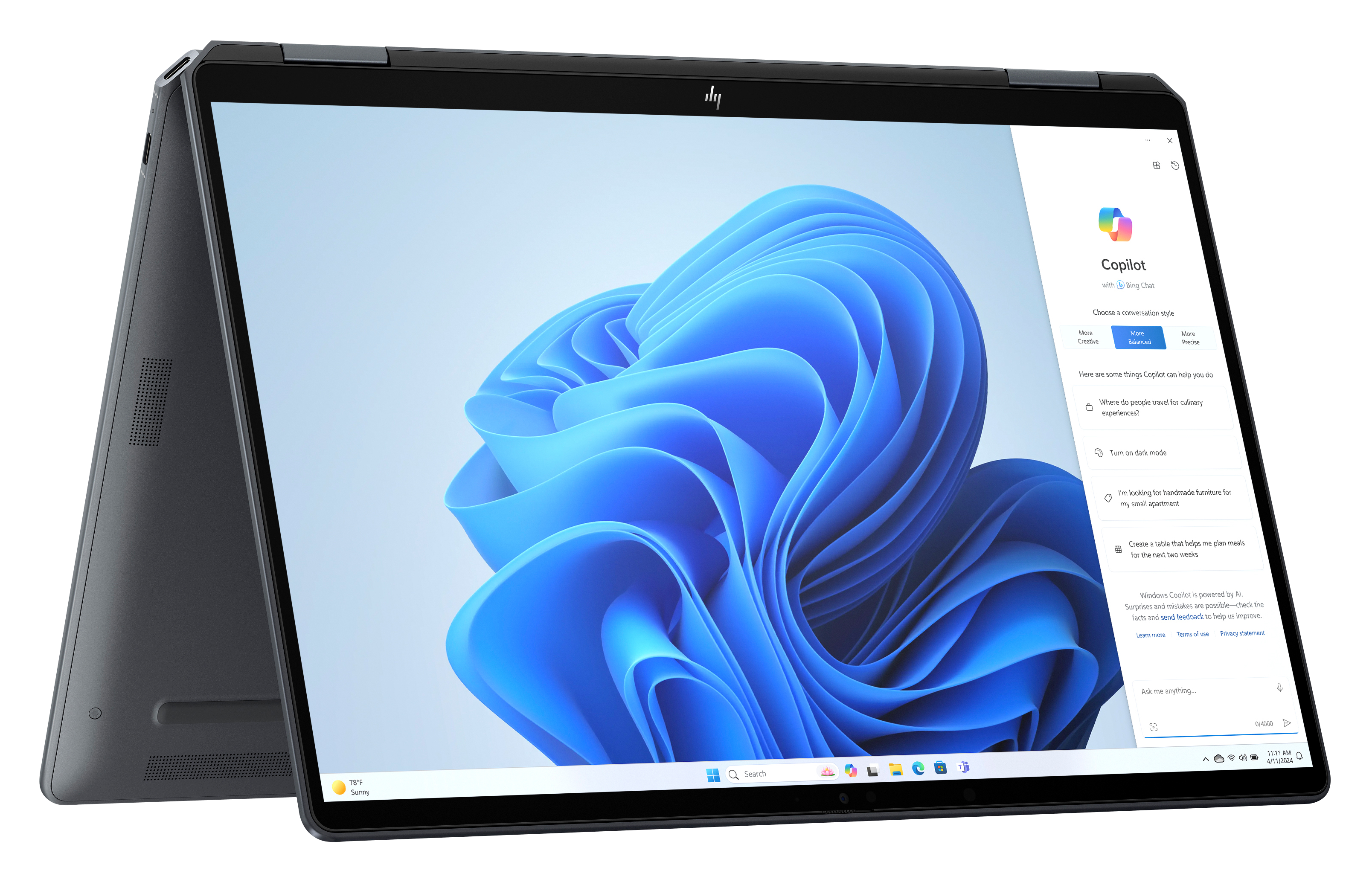 Otwarty laptop, z niebieską abstrakcyjną tapetą i oknem czatu Copilot. Ciemnoszara ramka, ikona słonecznej pogody.
