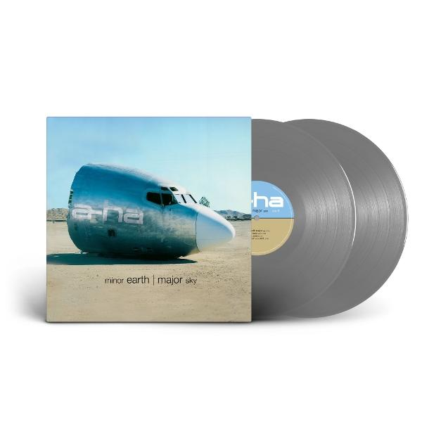 Albumcover von a-ha 'minor earth | major sky'. Zeigt einen Flugzeugrumpf am Boden und zwei graue Schallplatten.