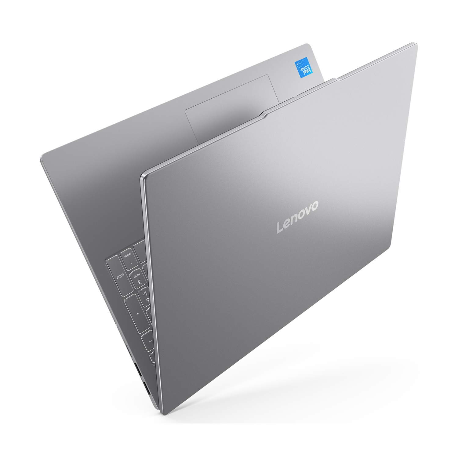 Un laptop Lenovo argento è leggermente aperto su sfondo bianco. La tastiera è visibile. L'adesivo Intel Core è in alto.