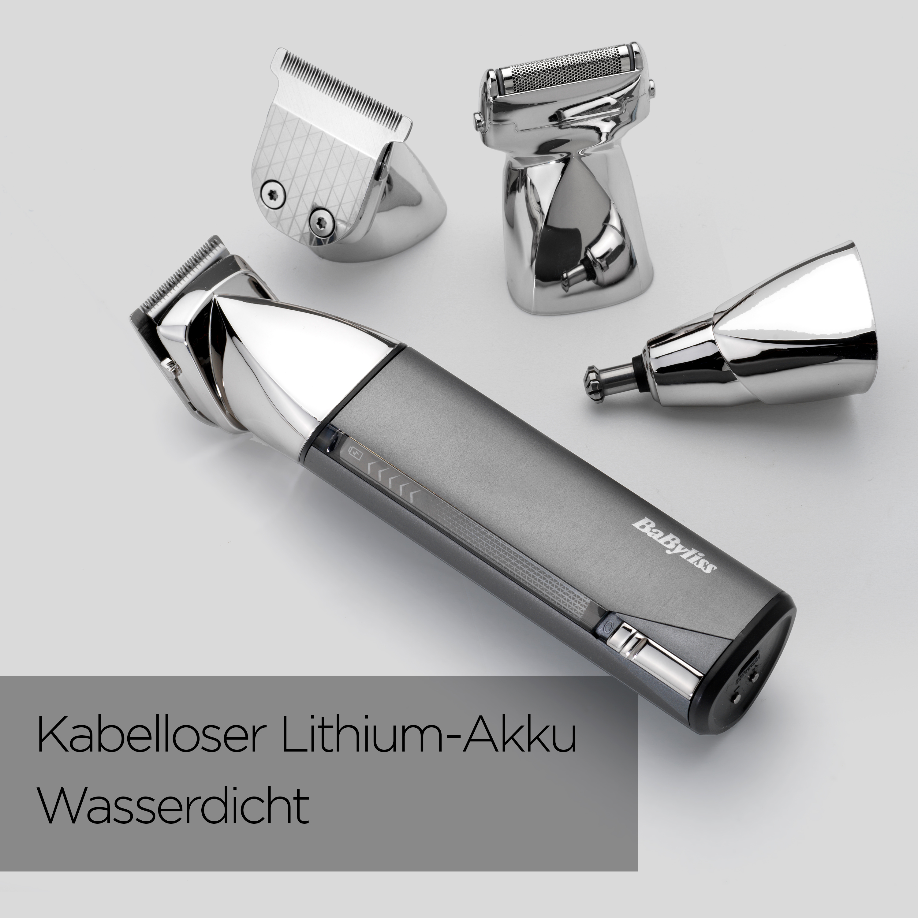 Ein grauer und silberner Babyliss-Haarschneider mit drei Aufsätzen auf weißem Hintergrund. Text: 'Kkabelloser Lithium-Akku Wasserdicht'.